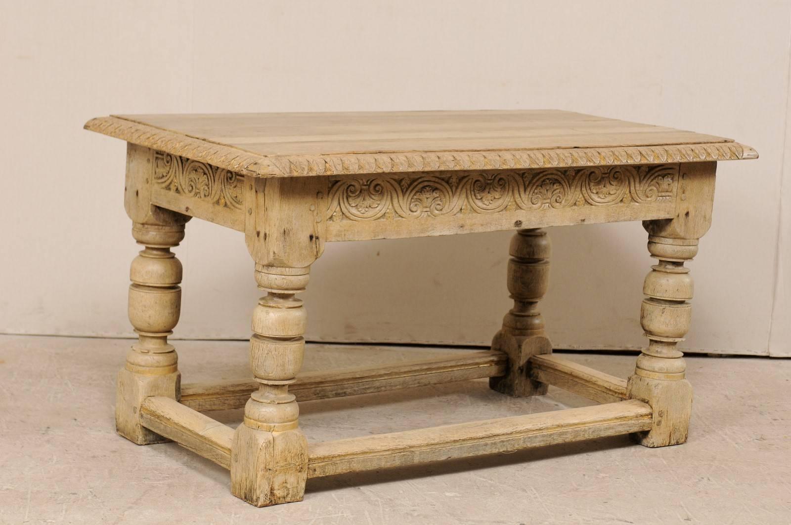 A French, 19th century table beautifully carved table with robust legs. This antique French table features a rectangular shaped top with exquisite leaf carvings and subtle gold accents around its edges. The skirt is intricately carved on all four
