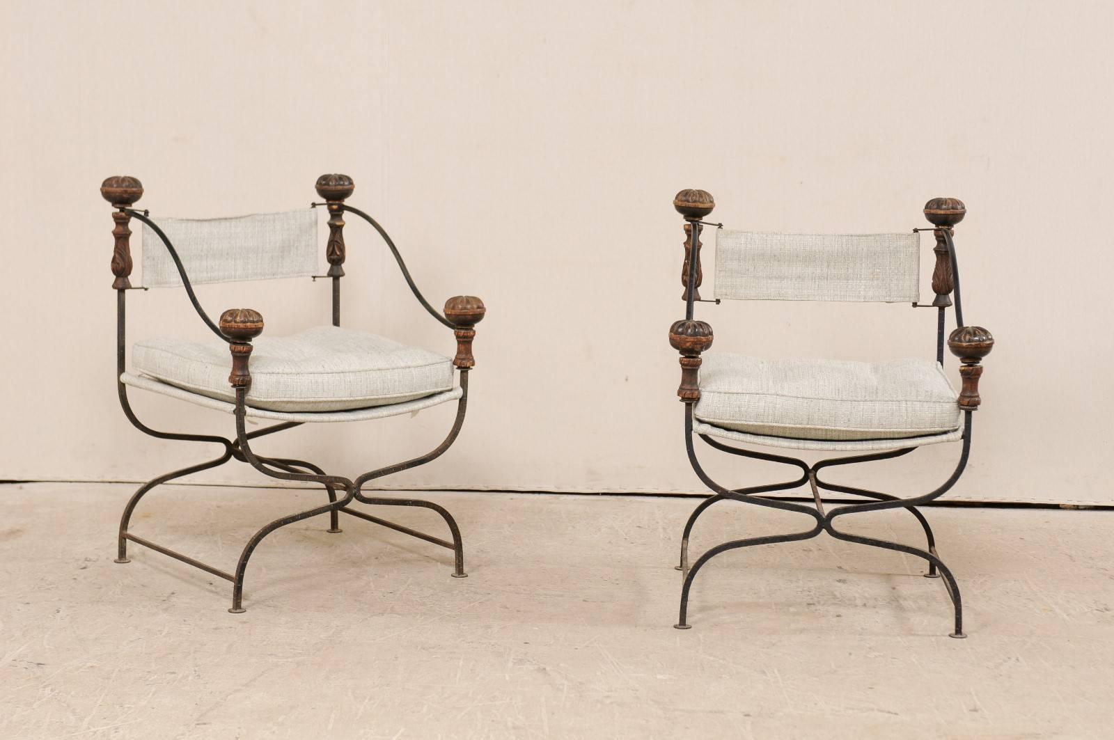 A pair of Italian dante iron and upholstered chairs from the early 20th century. This pair of antique Italian chairs feature signature dante frames, which flow down from their top, connecting inward at their front and back centres, and then curving