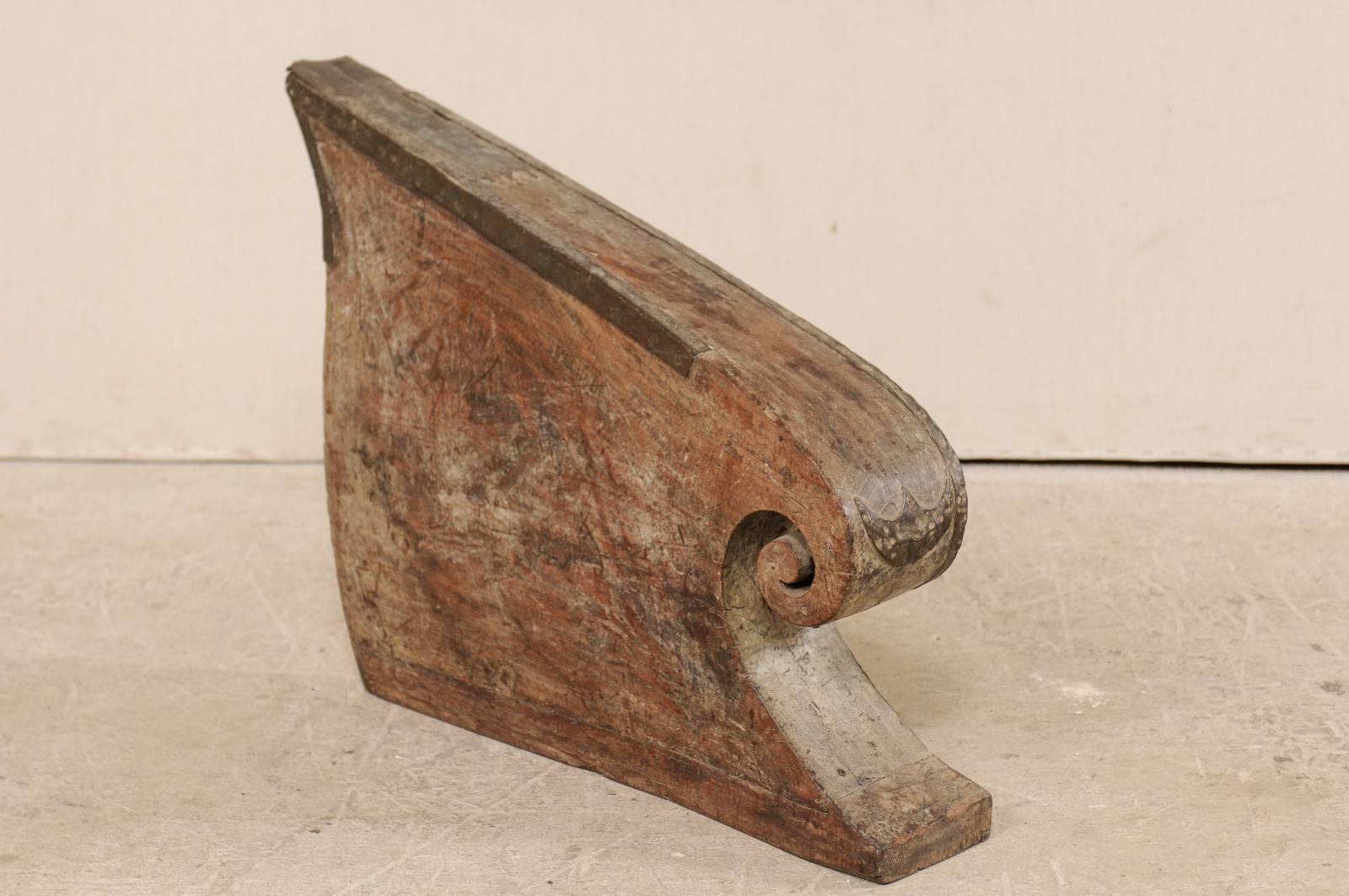 A South Indian (Kerala) wooden boat prow from the mid-20th century. This hand-carved boat prow from Kerala is adorn with curling volute and decoratively cut metal accented along it's top, sides and front, which have a beautiful salt water patina.