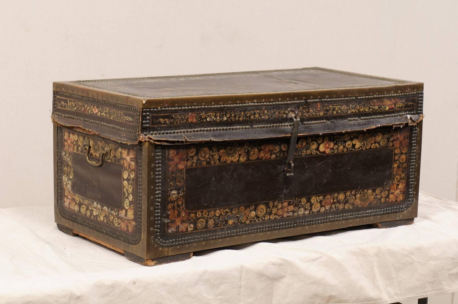 A 19th century Chinese camphor wood trunk. This antique Chinese camphor wood chest features a beautifully hand-painted flower motif on it's leather covered exterior, adorn with a decorative trimming of nail heads, and brass bound edges. The chest