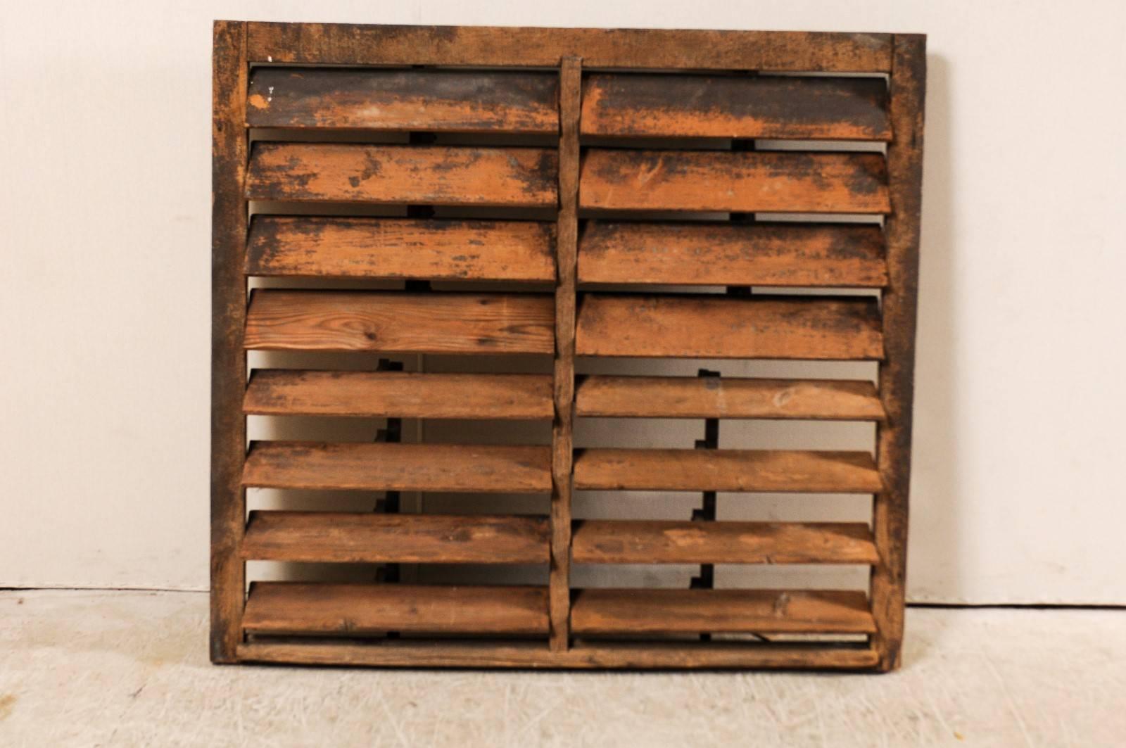 A vintage American large-size rustic wooden shutter. This vintage wooden shutter has a nice distressed look with beautifully aged wood finish that would add a rustic touch to any environment. Wooden louvers on the backside open and close to your