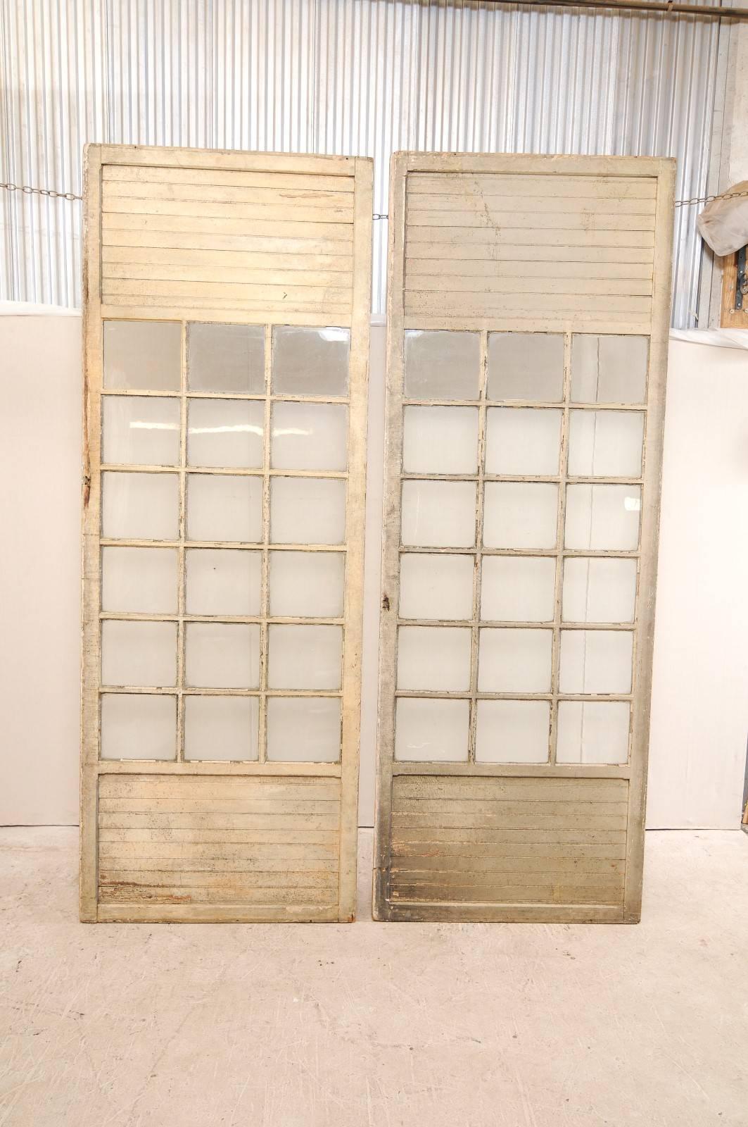 Intagliato Coppia di porte francesi in legno con pannelli di vetro alte più di 10 piedi, risalenti ai primi anni del XX secolo. in vendita