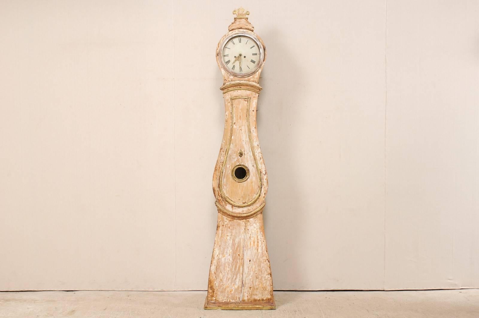 Une horloge grand-père suédoise en bois sculpté du 19ème siècle. Cette grande horloge ancienne du nord de la Suède présente une feuille en éventail empilée et surélevée à son sommet, et accentuée par des moulures autour du cou et de la taille. La