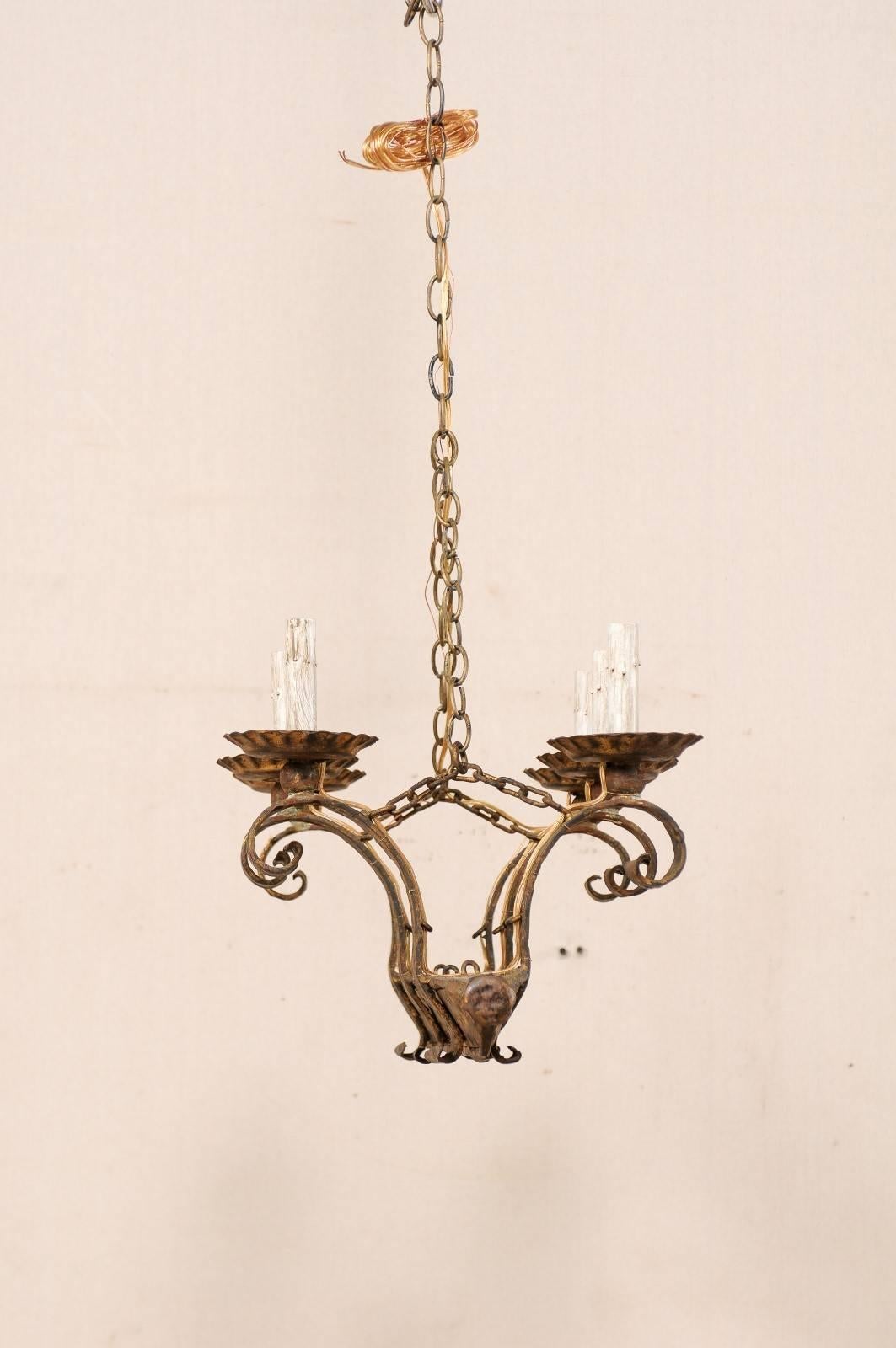 A vintage French six-light chandelier. This French chandelier from the mid-20th century of forged iron has an oblong lower beam which gives rise to six arms, three at each long side, giving the chandelier a distinctive v-shaped side profile. Each