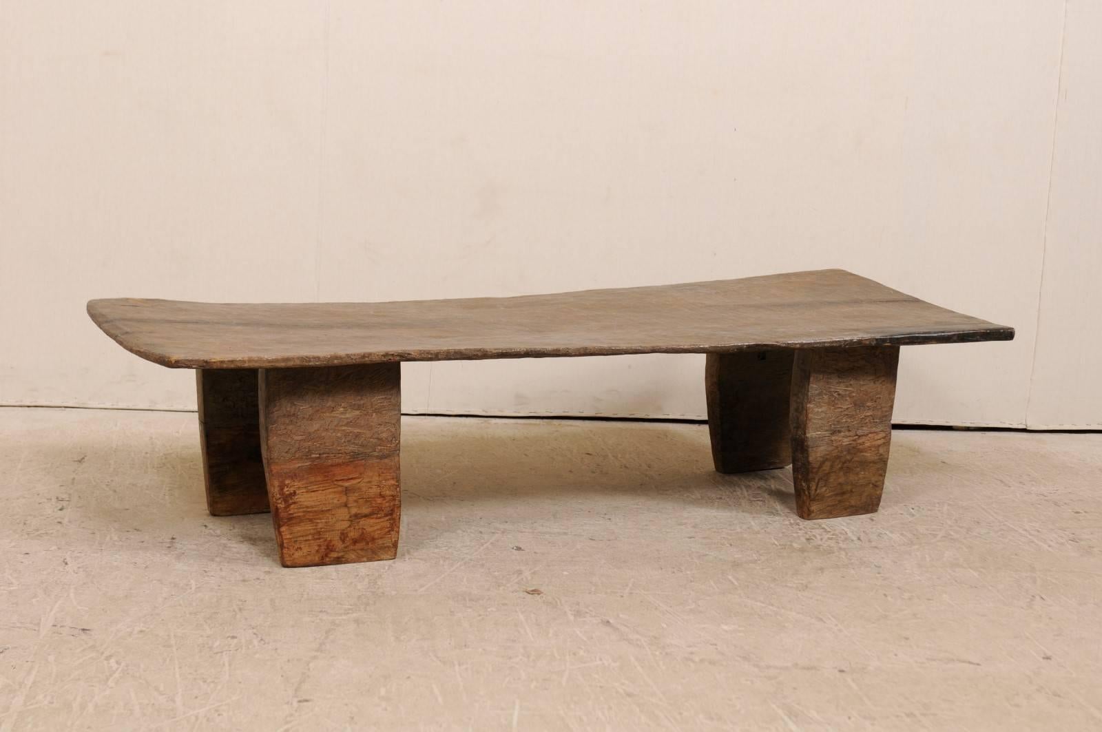 A Primitive wood Naga coffee table from the late 19th-early 20th century. This turn of the century coffee table was originally used as a wooden bed from the Naga tribes of Nagaland, North East India. This piece has been carved out of a single log