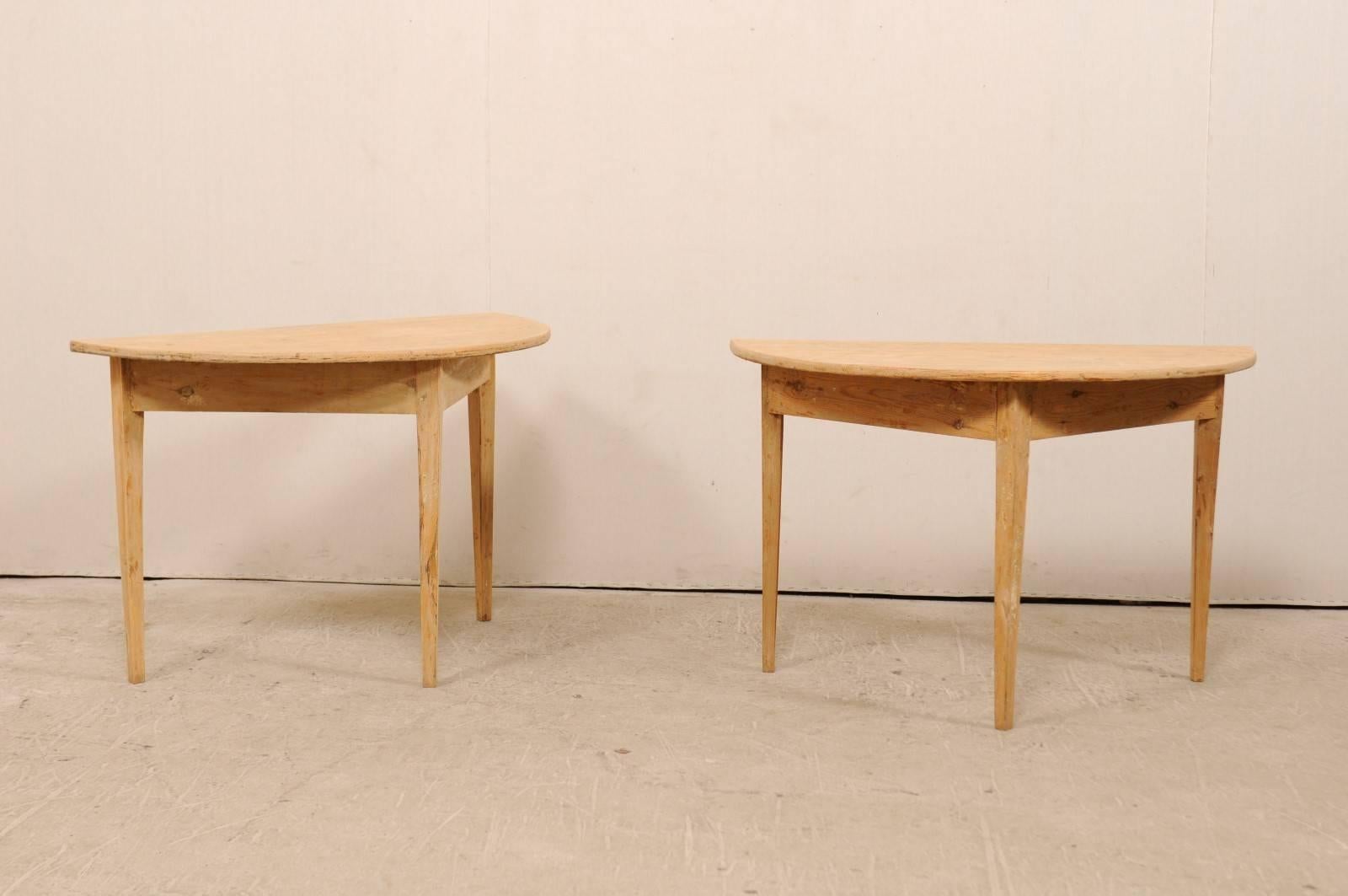 A pair of 19th century Swedish painted wood demilune tables. This pair of Swedish demilune tables from the 1880s features a semi-circular, or half moon top, over a triangular shaped apron. These demilune tables have plain skirts, and are each raised