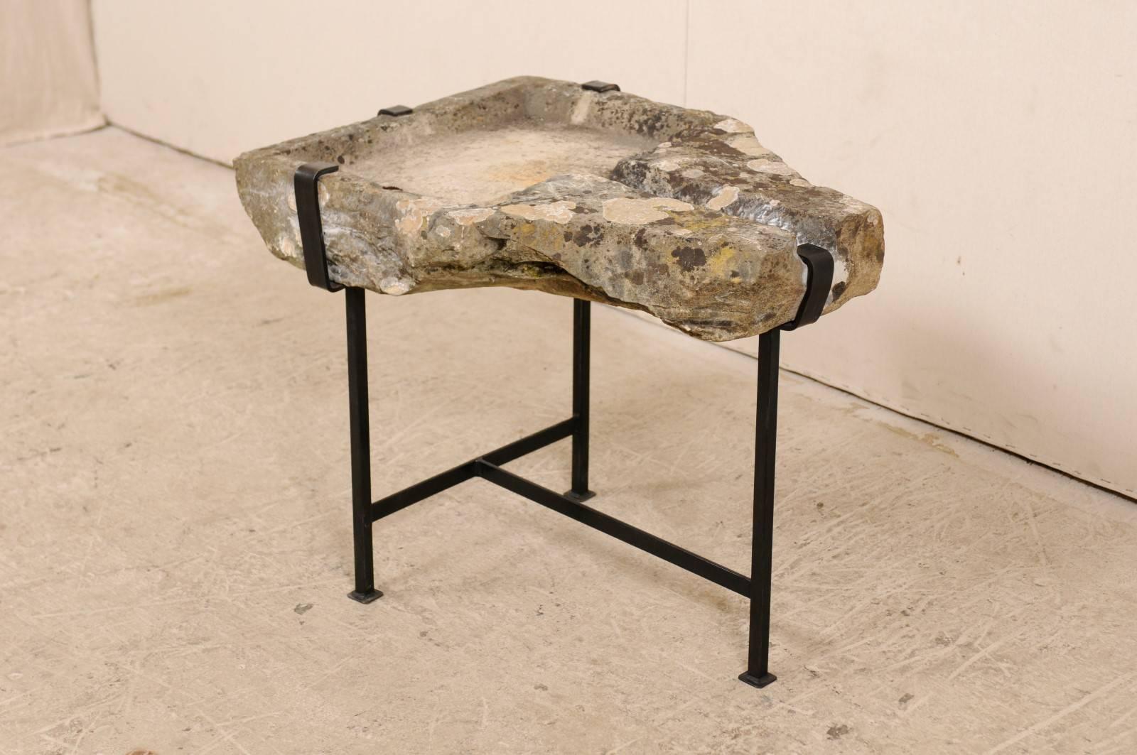 An early 19th century French stone trough coffee table on custom base. This unique coffee table features a top made from a French stone trough which dates back to the early 19th century (or possibly older). The stone trough top is supported by a