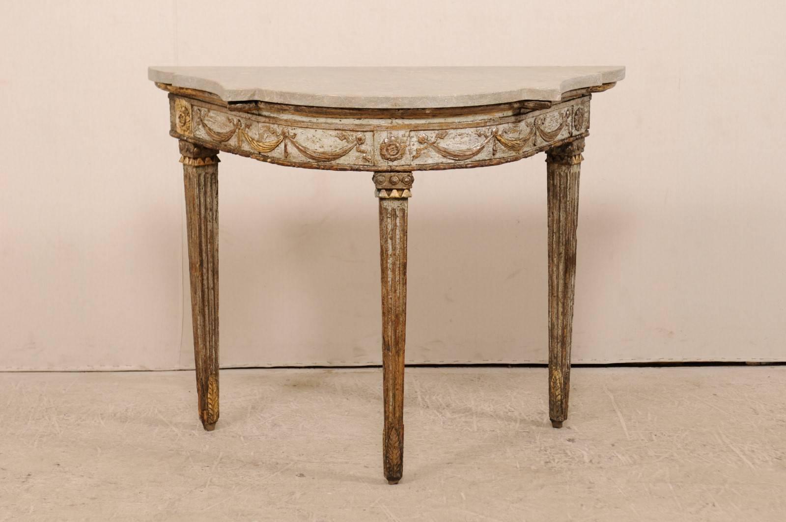 An Italian gilt demilune console table from the 18th century with fossilized granite top. This fabulous antique Italian carved wood demilune table retains it's original gold and silver gilt finish and has a nicely shaped fossilized and honed granite