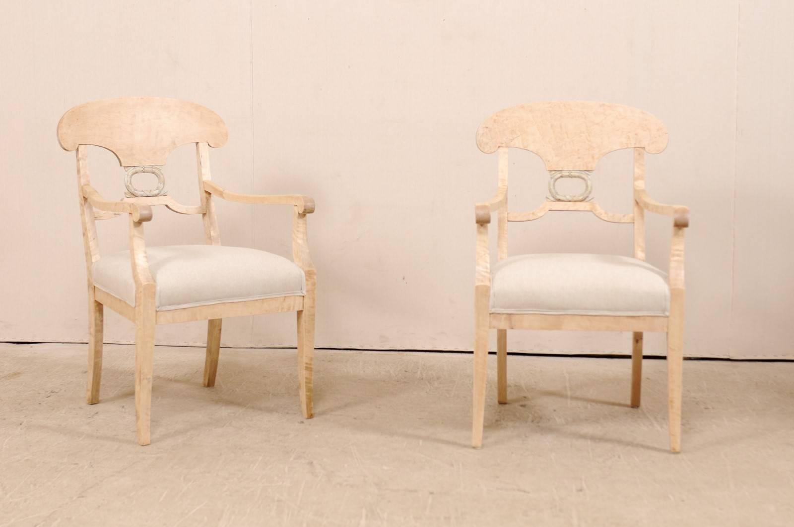 A pair of Swedish Biedermeier or Karl Johan arm chairs from the late 1800s. These 19th century Swedish bleached curly birch arm chairs feature classically curved 