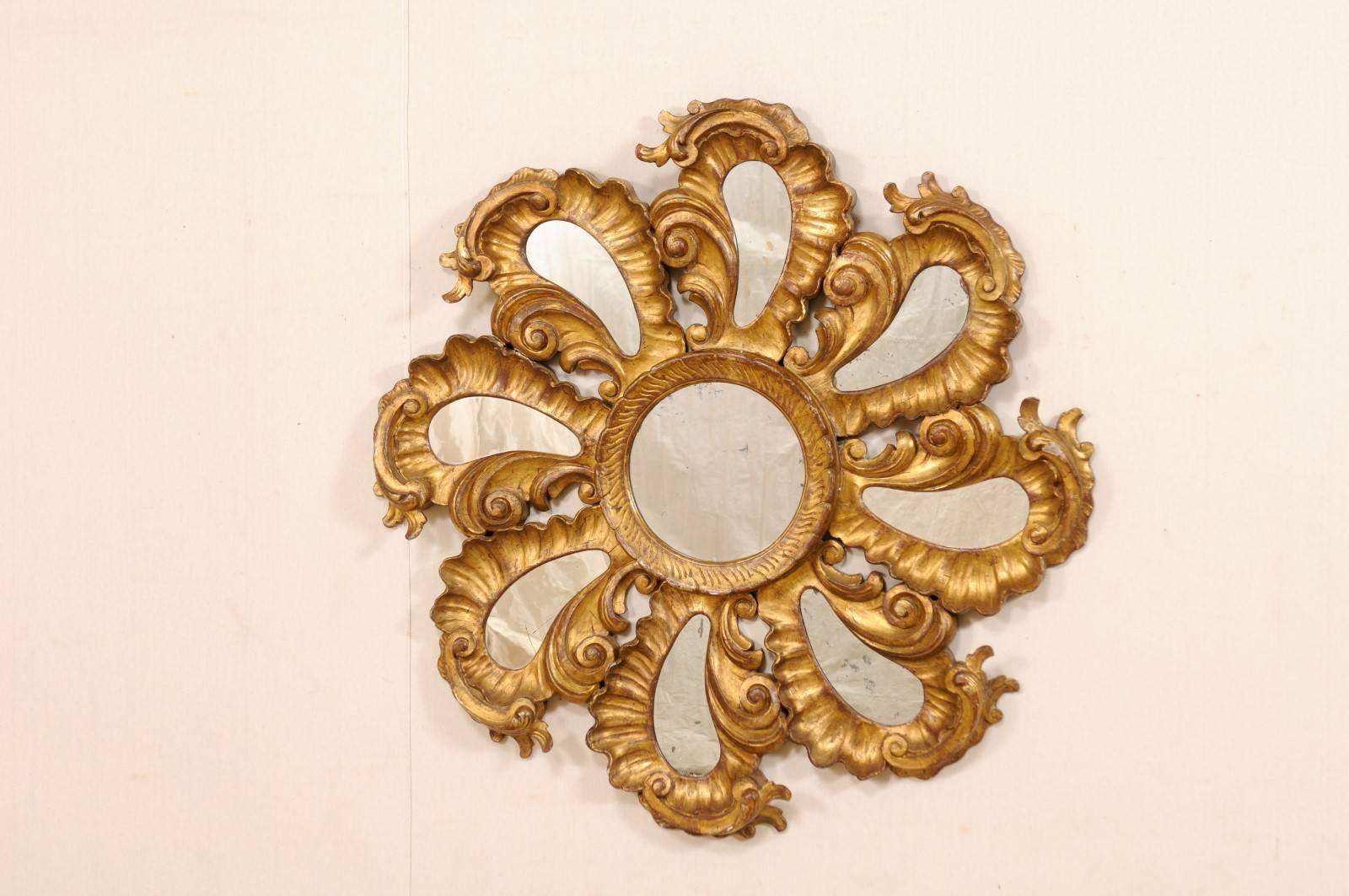 A vintage Italian good gilt and carved wood flower-shaped mirror. This spectacular gilded Italian mirror is comprised of circular-shaped center mirror which is surrounded by whirling, and richly carved petal-shaped extensions, each with mirrors at