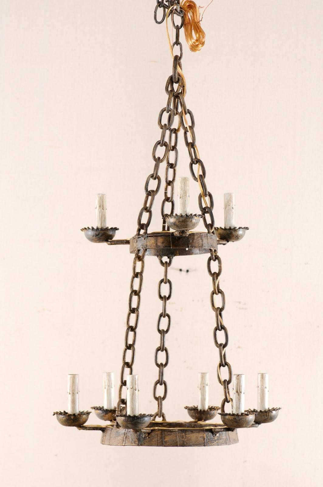A vintage French nine-light iron chandelier with two-tiered rings. This French two-tiered iron chandelier from the mid-20th century features a lower ring with six lights, and a smaller-sized upper ring consisting of three lights. Each arm projects