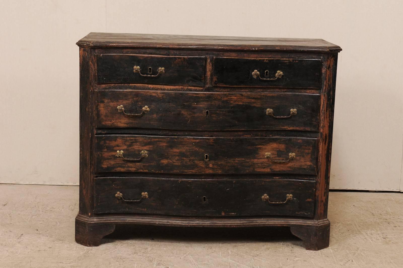 An 18th century Italian five-drawer wood chest. This antique Italian commode has a slightly bowed front with canted side posts, giving it a subtly curvy shape. There are two half drawers over three full drawers, each with rosette mounts and bail