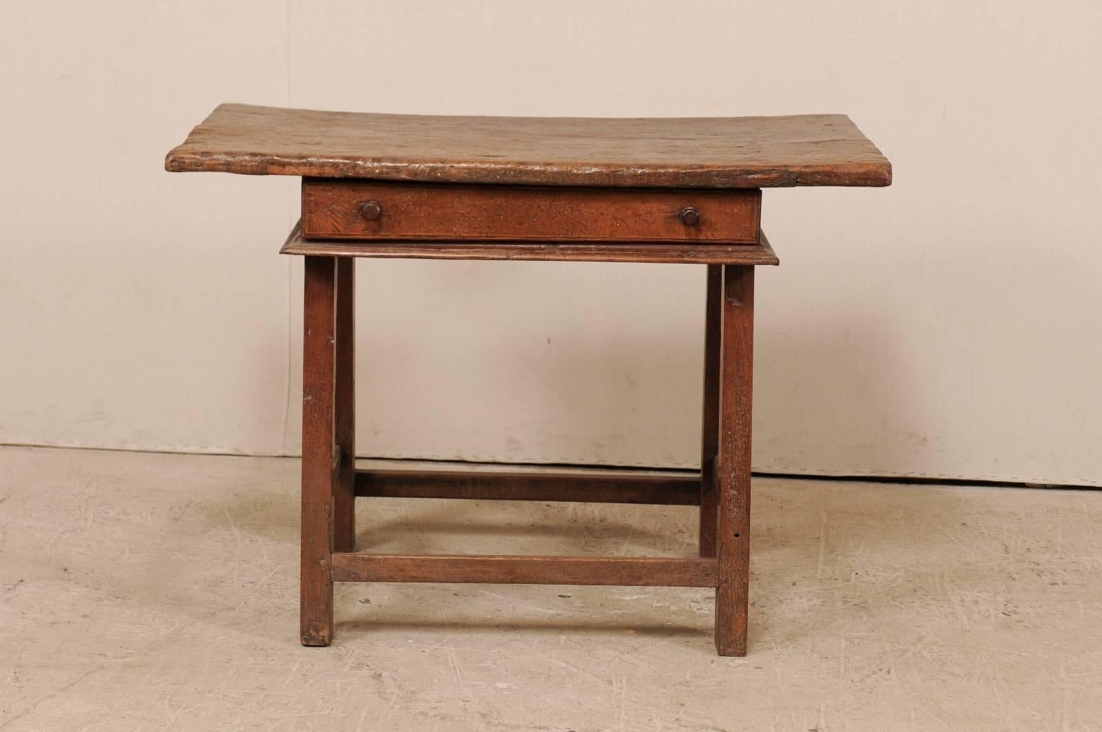 An 18th century Brazilian table. This antique Brazilian table has a single drawer and wooden stretchers along all sides, and an overhanging rectangular-shaped top. The table is comprised of peroba wood (a tropical native hardwood, 35% harder than