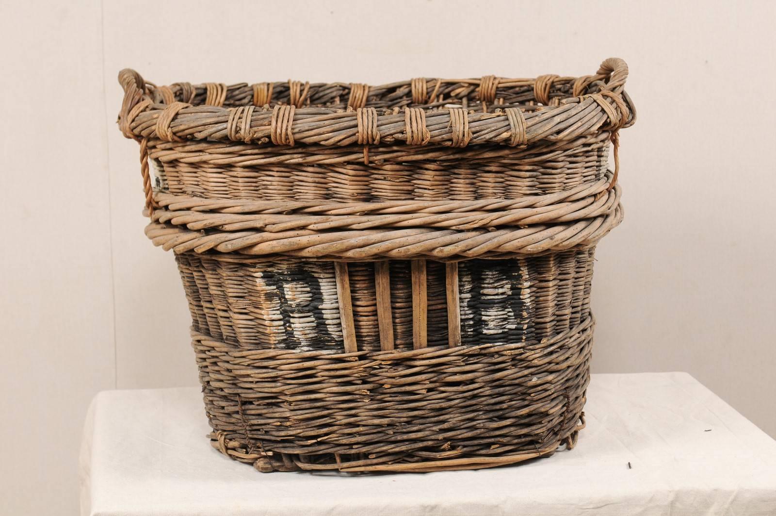 An antique French grape harvesting basket. This midcentury French basket is an excellent example of the baskets that were commonly used by the estates of Reims, France (the Champagne region) during the harvesting of grapes. The basket is nicely