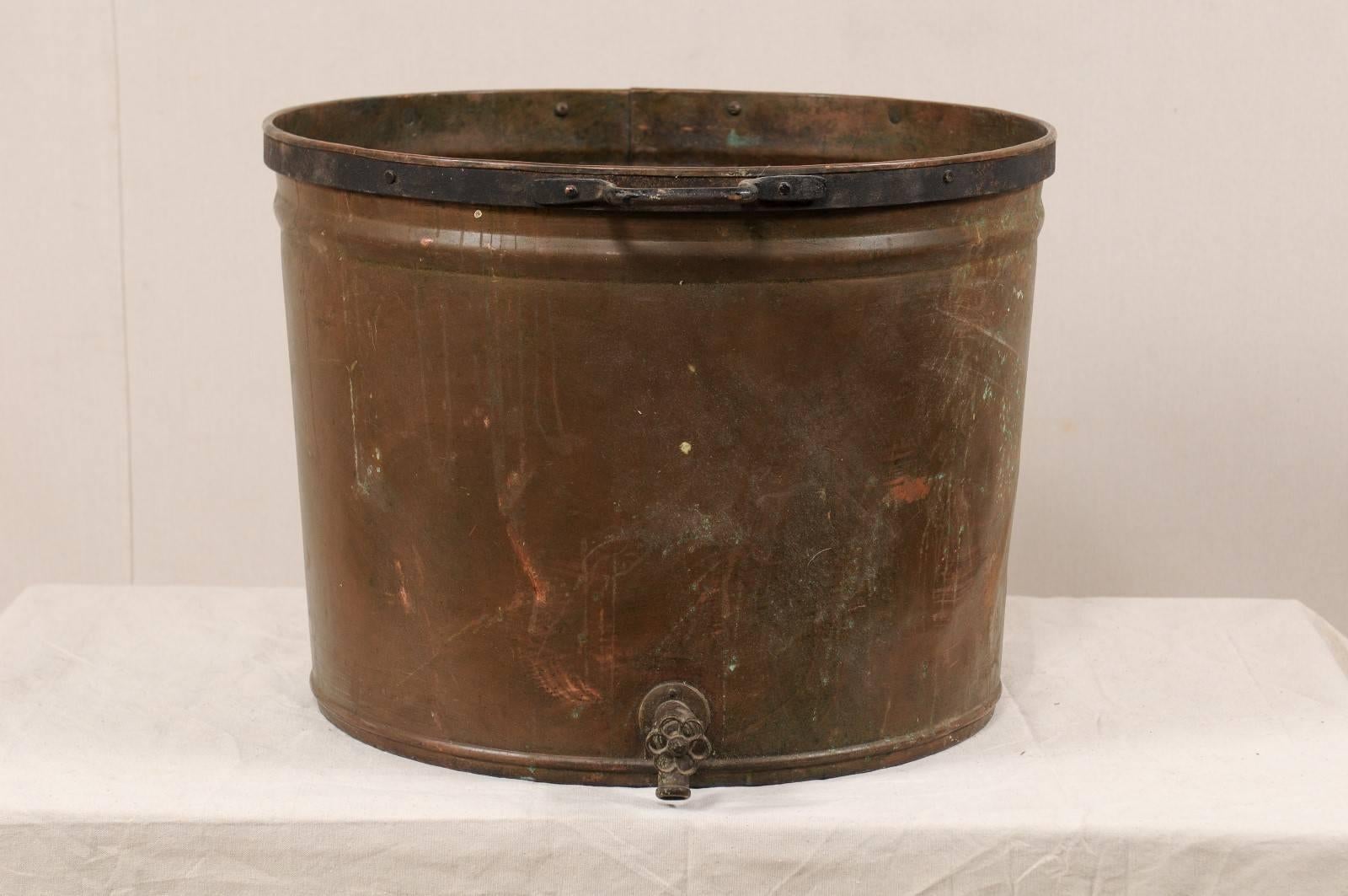 A vintage French large-sized copper kitchen pot. This mid-20th century French farmer's kitchen pot is nicely sized at 2 ft wide. The pot has two side handles and a spout (allows for easier drainage of liquids) which is located at the bottom