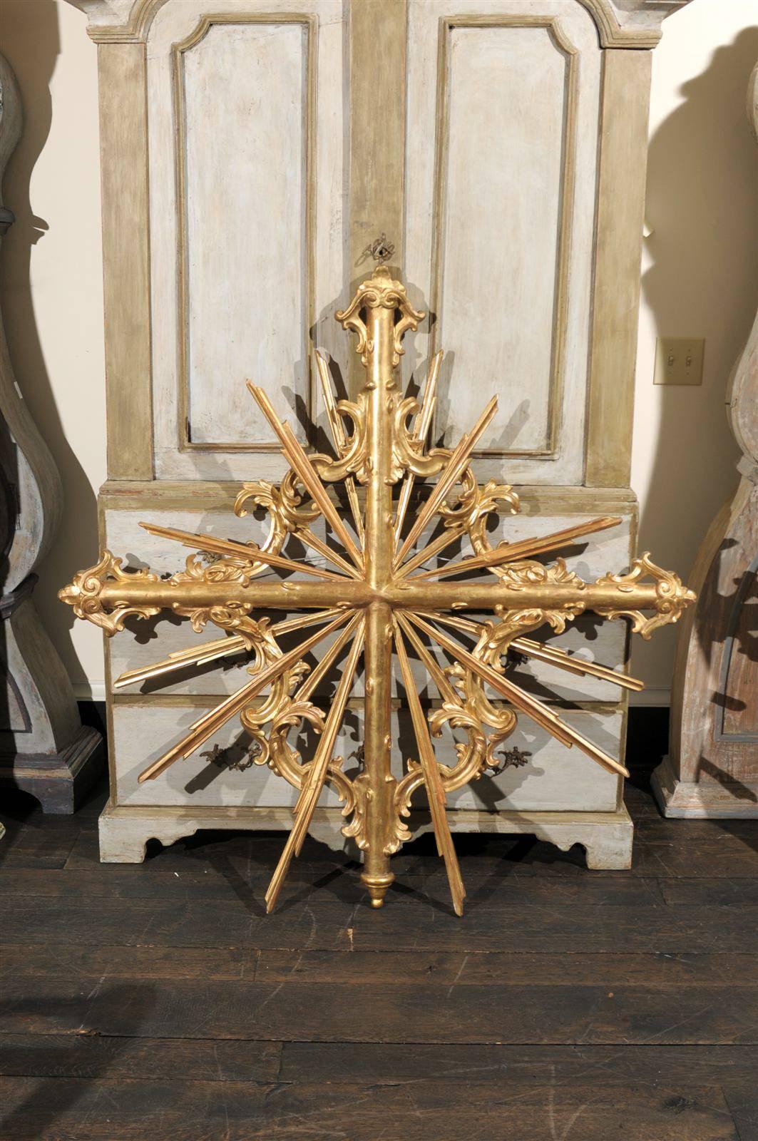 A 19th century large size gilded wood Italian cross over sunrays with exquisite carving.