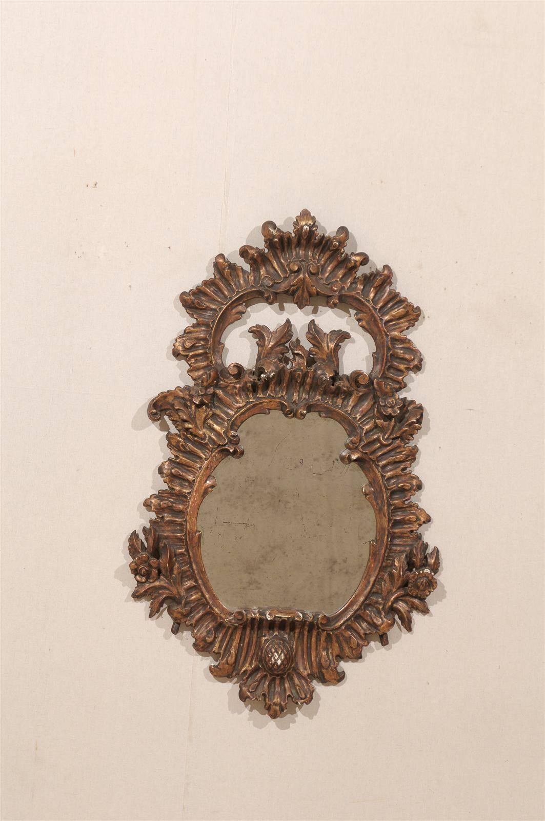 A 19th century richly carved Italian wooden mirror with foliage décor and discreet flowers. Wonderfully carved crest at the top.