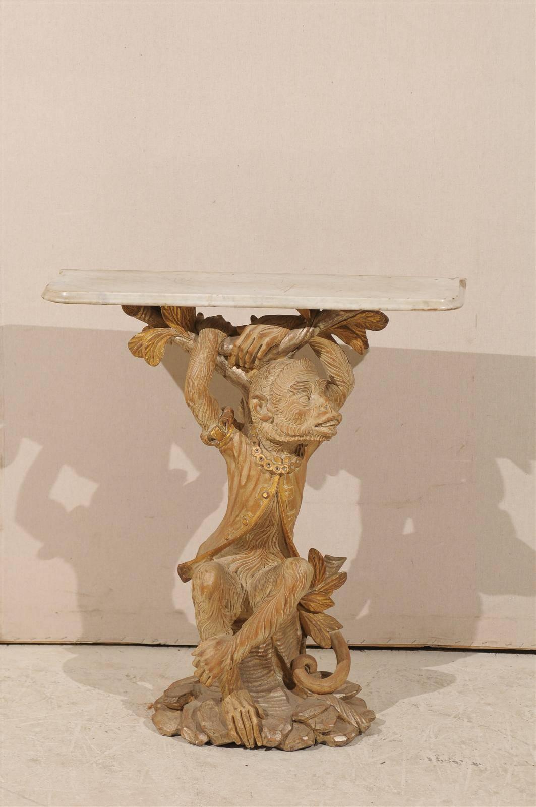 An Italian Console Table with Wooden Carved Monkey Base (The Monkey is Dressed and Accessorized) with Gilded Accents and Marble Top from the 20th Century. 