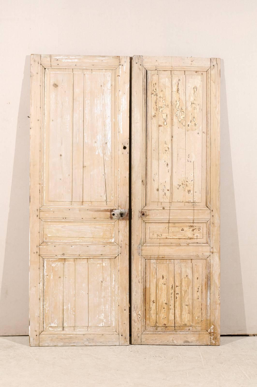 A pair of 19th century French wooden doors, dry scraped with carved panels.
 