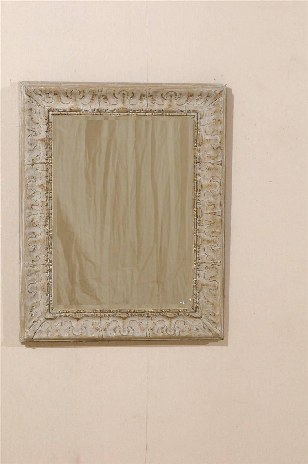 A pair of Venetian style mirrors with nicely carved and painted wood frames. These 20th century American made mirrors have a subtle and unique stylized swirl patterned border. In the inner surround of the border there is also a nice bead motif