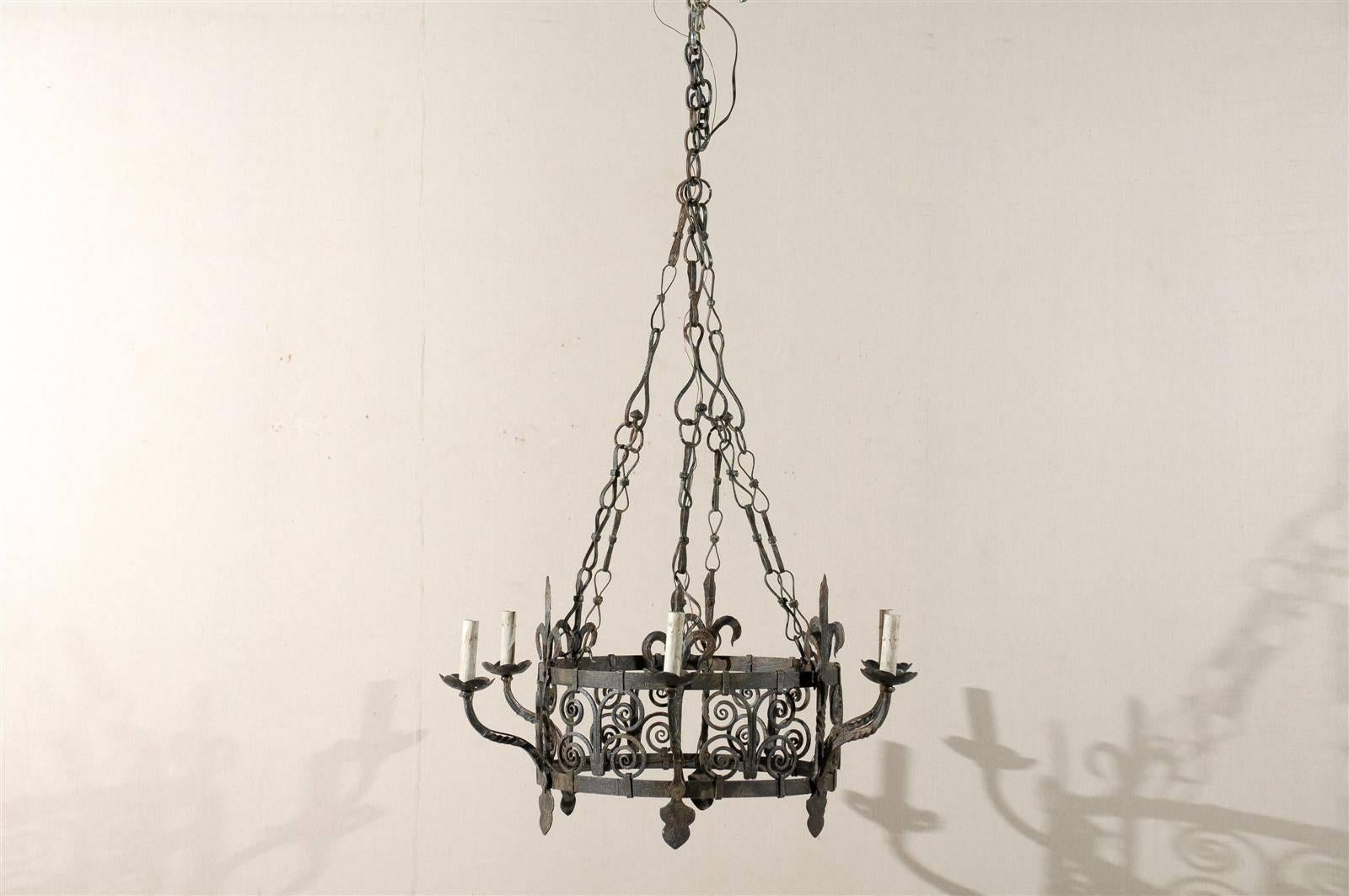 A French Gothic style mid-20th century iron six-light chandelier with stylized fleurs-de-lys as well as scrolled motifs on the central circular ring.

This iron chandelier has been rewired for the US and comes with a complimentary 3 foot chain and