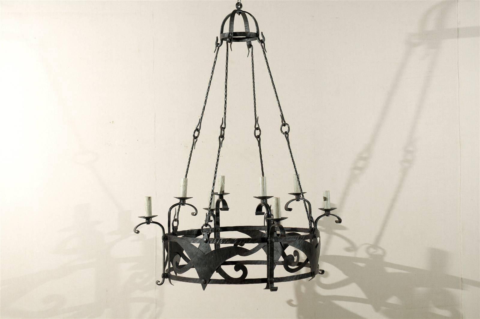 A large sized Italian mid-20th century eight-light chandelier with stylized motifs on the circular ring and domed canopy.  This chandelier has a wonderful old rusty black oxidized finish.

This iron chandelier has been rewired for the US and comes