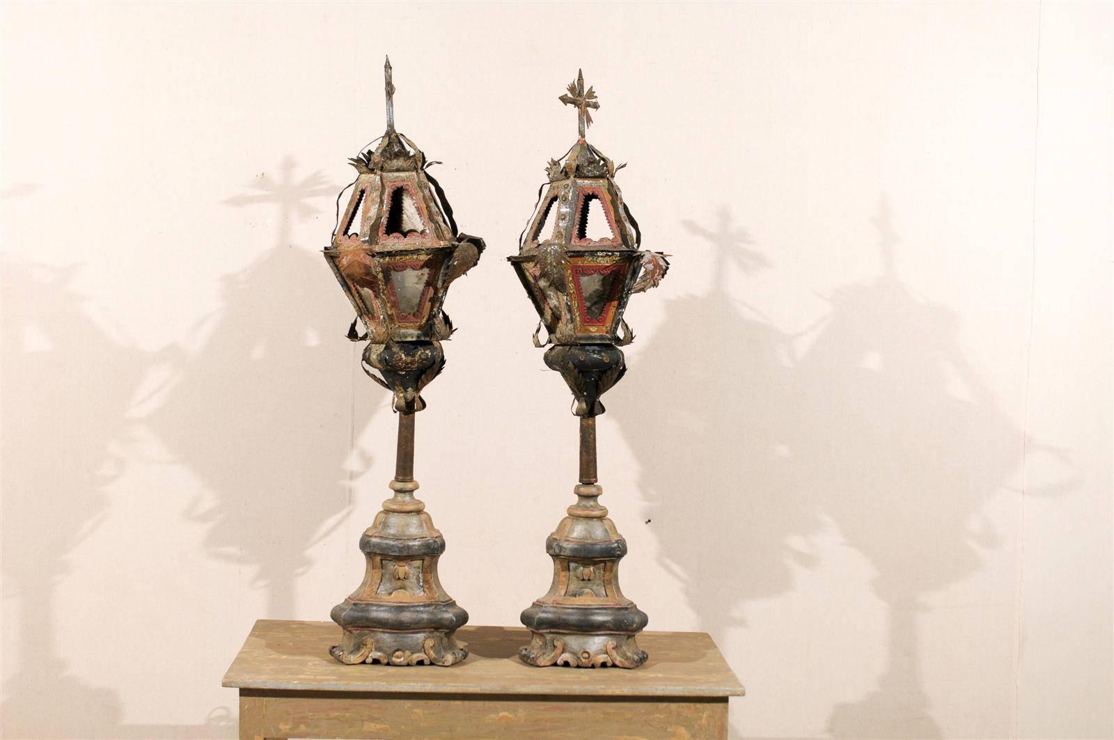 A pair of exquisite 19th century Italian painted metal table lamps on later painted wood bases with rusty look, nice red and orange paint color, topped with crosses and sun rays. They are also ornate with acanthus leaves. These lamps stun by their