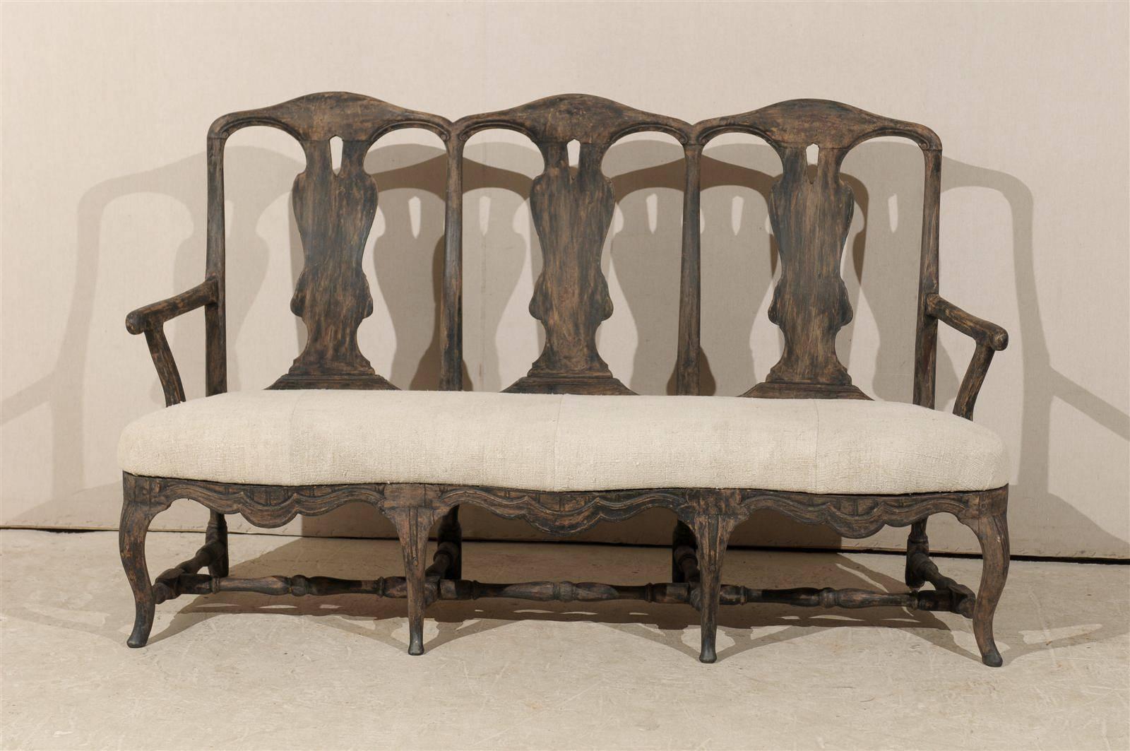 A Swedish period Rococo 19th century three-chair back sofa scraped to its original finish, cabriole legs, nicely carved skirt and cross stretcher and upholstered seat.