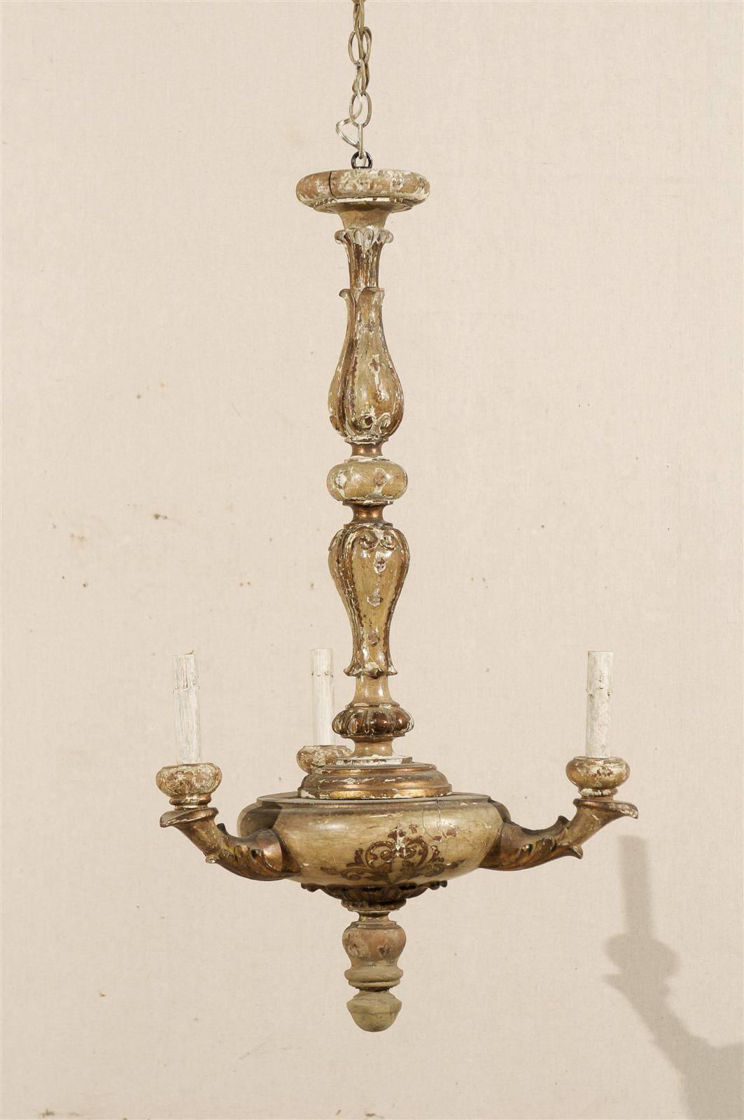 An Italian three-light gilded and painted wood chandelier with nice floral decoration on the body and central wooden column. From the early 20th century.

This gilded and painted wood chandelier has been rewired for the US and comes with a