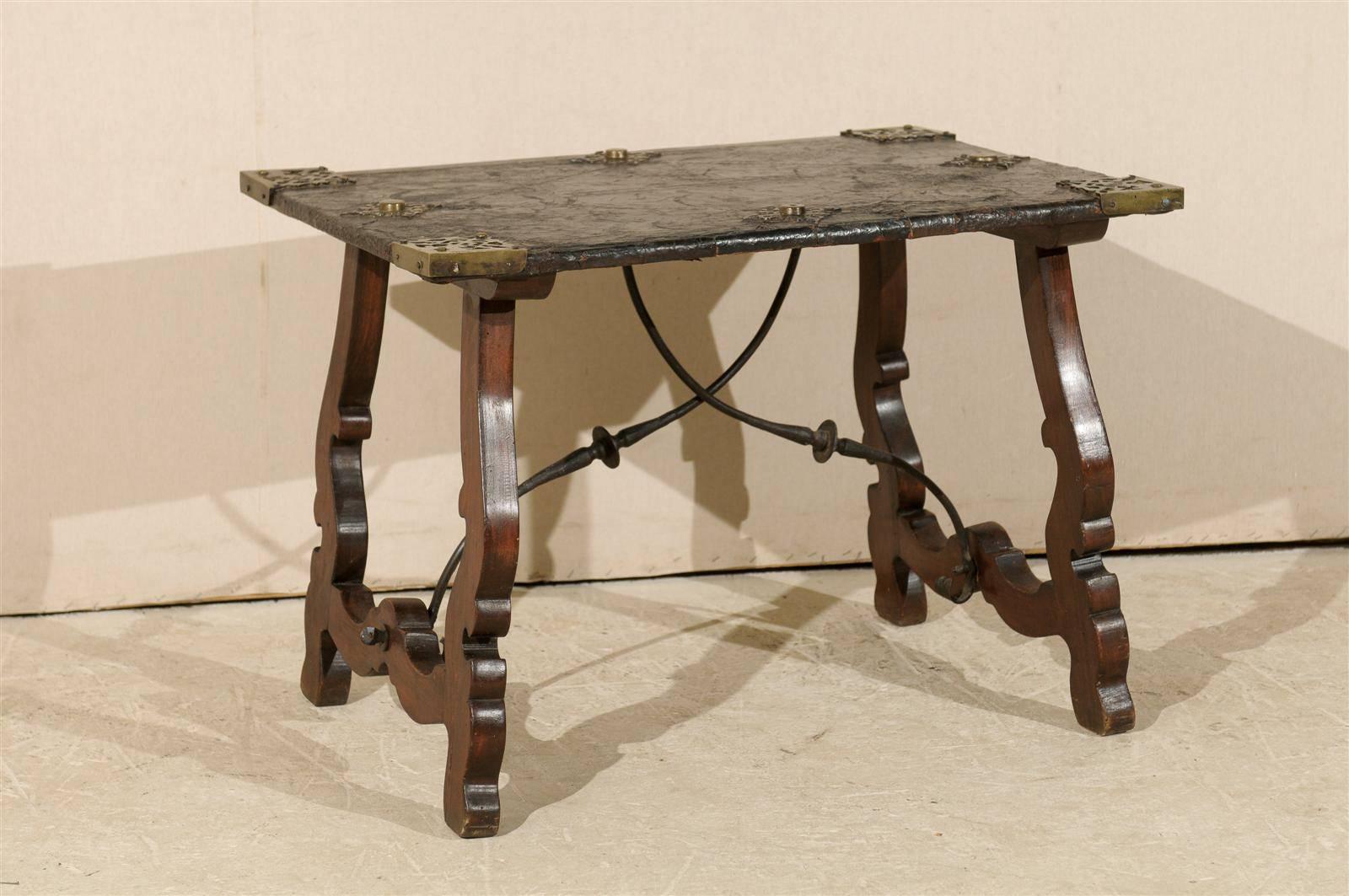 A Spanish 19th century leather top Spanish coffee table with iron stretcher and brass accents.
 