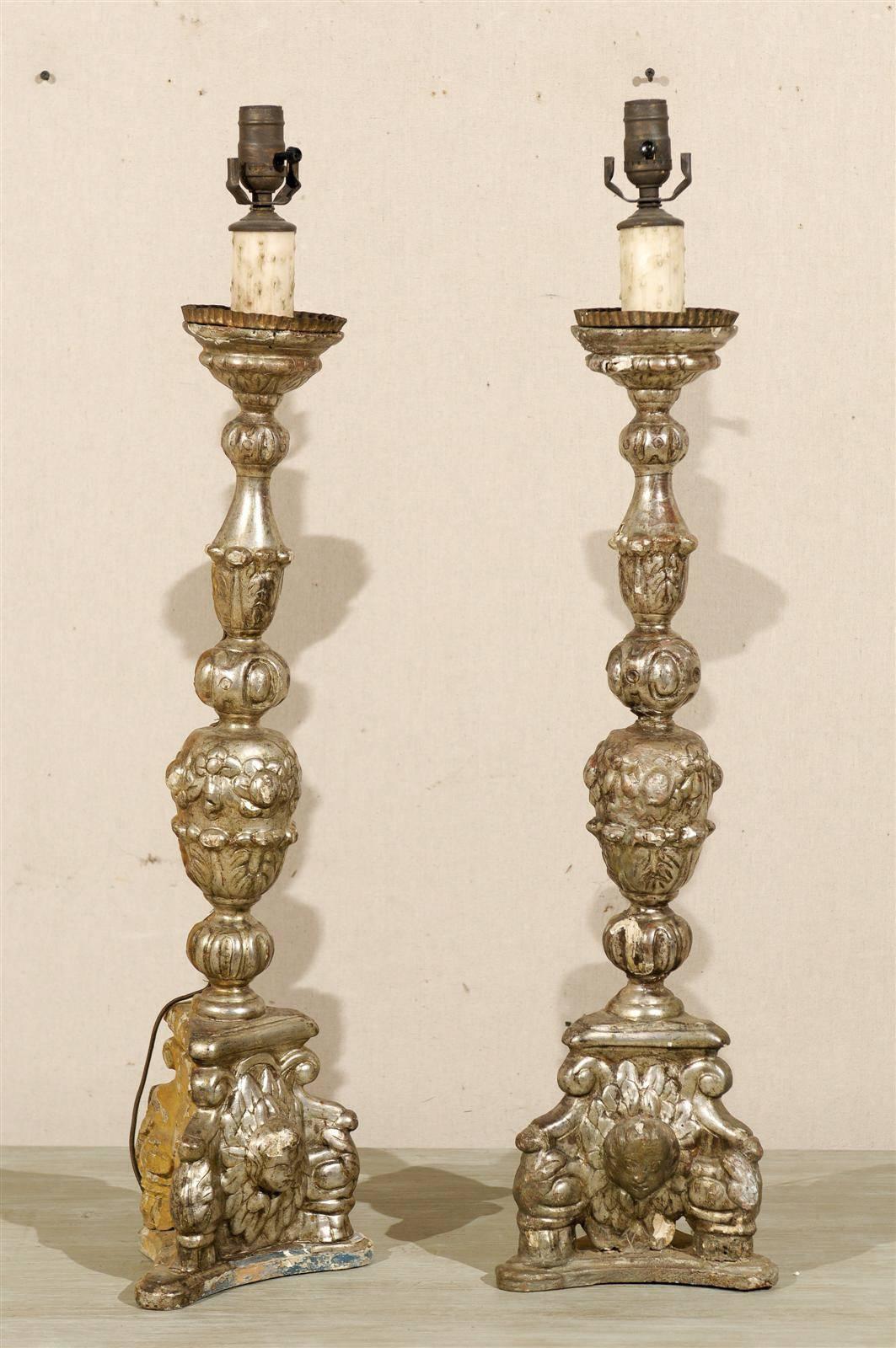 A Pair of Italian giltwood 19th century candlesticks made into table lamps. Silver gilt over Gesso.

This pair of 19th century candlestick lamps has been wired for the US.
   