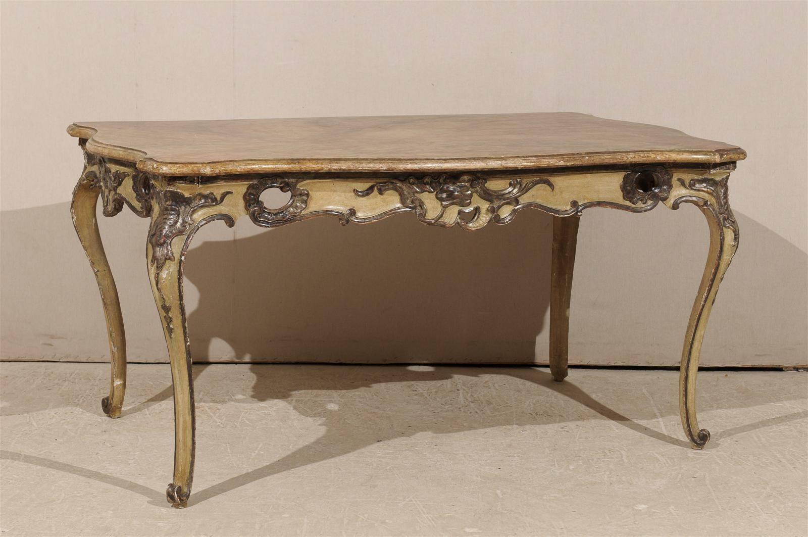 A Mid 19th Century Italian Table / Desk with Original Paint and Faux Marble Top, Wonderfully Carved Apron and Cabriole Legs on Scroll Feet.

This 19th Century Italian table, with its beautifully carved apron adorned with Rococo and pierced motifs