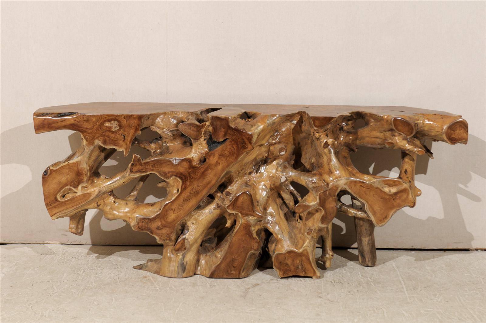 An Indonesian teak root wooden console table of interesting shape. 

With its flat back this table would be perfect placed against a wall. It is made of teak wood, which is a tropical hardwood, particularly valued for its durability and water