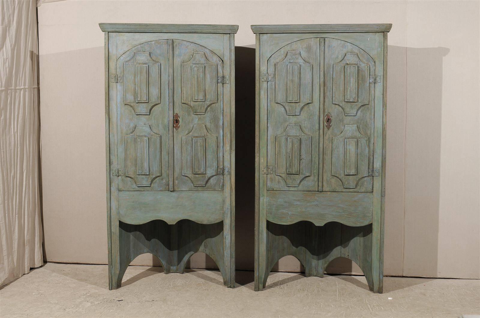 A pair of 19th century Brazilian painted wood tall corner cabinets with beautifully arched and decoratively paneled doors. This pair of antique corner cabinets from Brazil, nicely sized at approximately 7.5 feet in height, feature a pair of