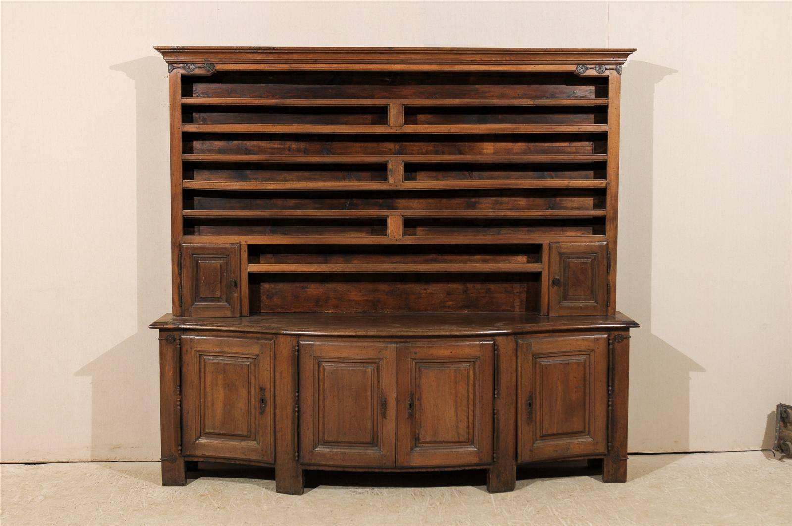 A 19th century English large size wood vaisselier / display and storage cabinet with bowed front section. This vaisselier features a top with open shelving, flanked by two small doors at the bottom section, which rests atop the lower half of the