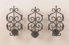 A Set of Three French Two-Light Forged Iron Sconces Featuring Scroll Decor