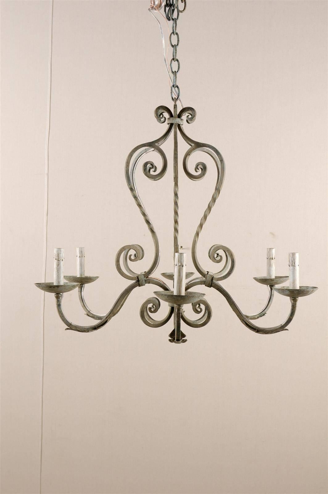 A French painted iron six-light chandelier. This French vintage mid-20th century light fixture is made of a succession of scrolls, giving a very curvy look to the chandelier. The little scrolls at the top are gathered inside a link and flow to six