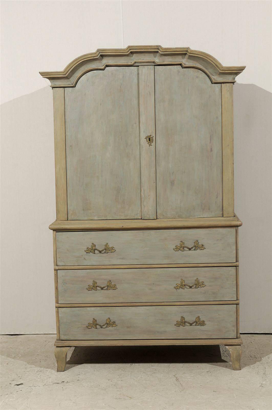 An exquisite Swedish period Rococo painted wood cabinet, circa 1760. This cabinet / linen press features two upper doors over three dovetailed drawers as well as a profiled pediment. It is raised on small cabriole feet. The color is light blue with