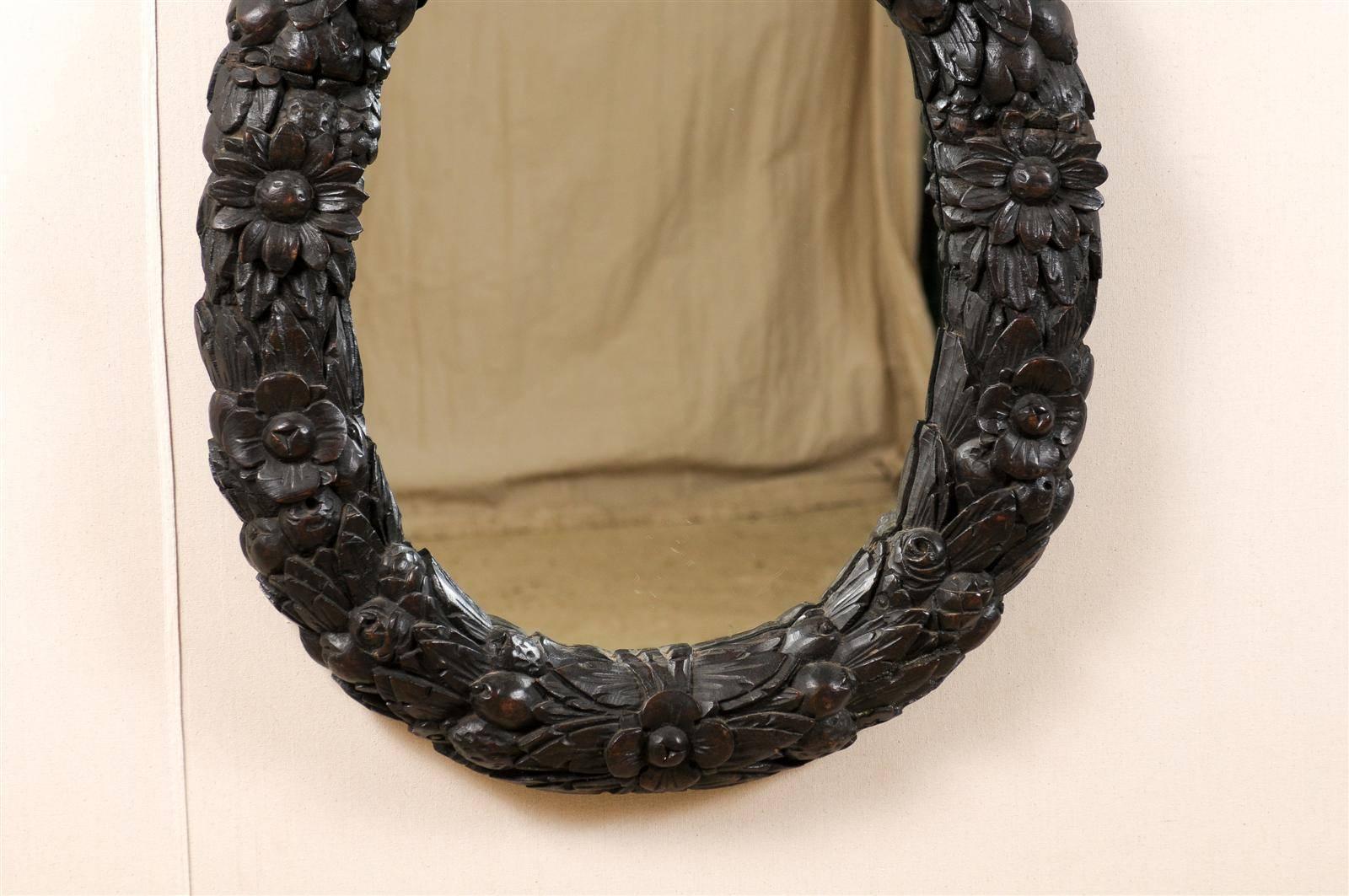 18th Century and Earlier An 18th Century English Oval Richly Carved Deep Brown Colored Wood Wall Mirror For Sale