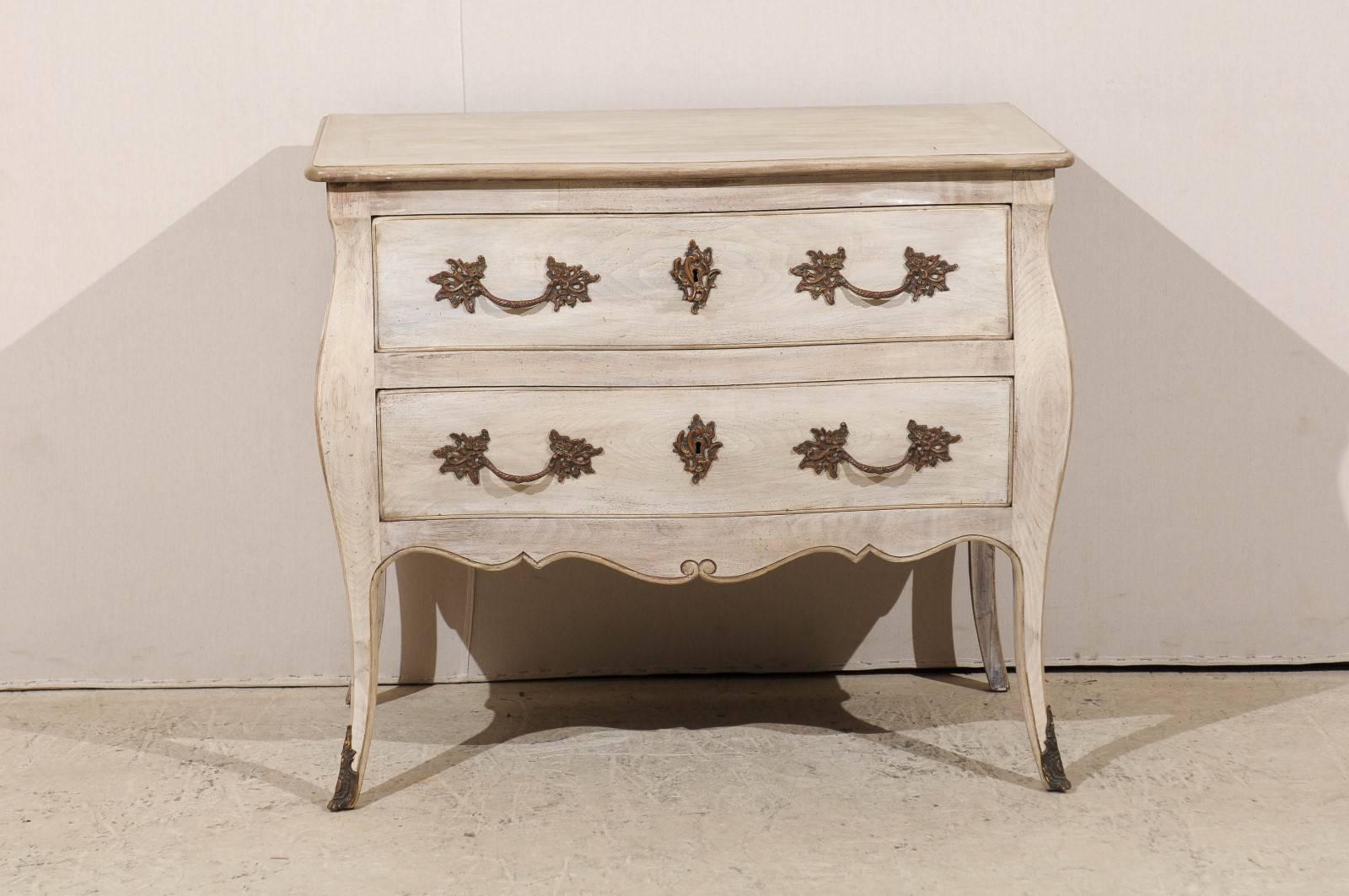 A French painted wood two-drawer raised chest from the late 19th century to early 20th century. This turn of the century chest from France has a nice bombé shape with scalloped and profiled skirt. The drawers are ornate with Rococo style hardware.