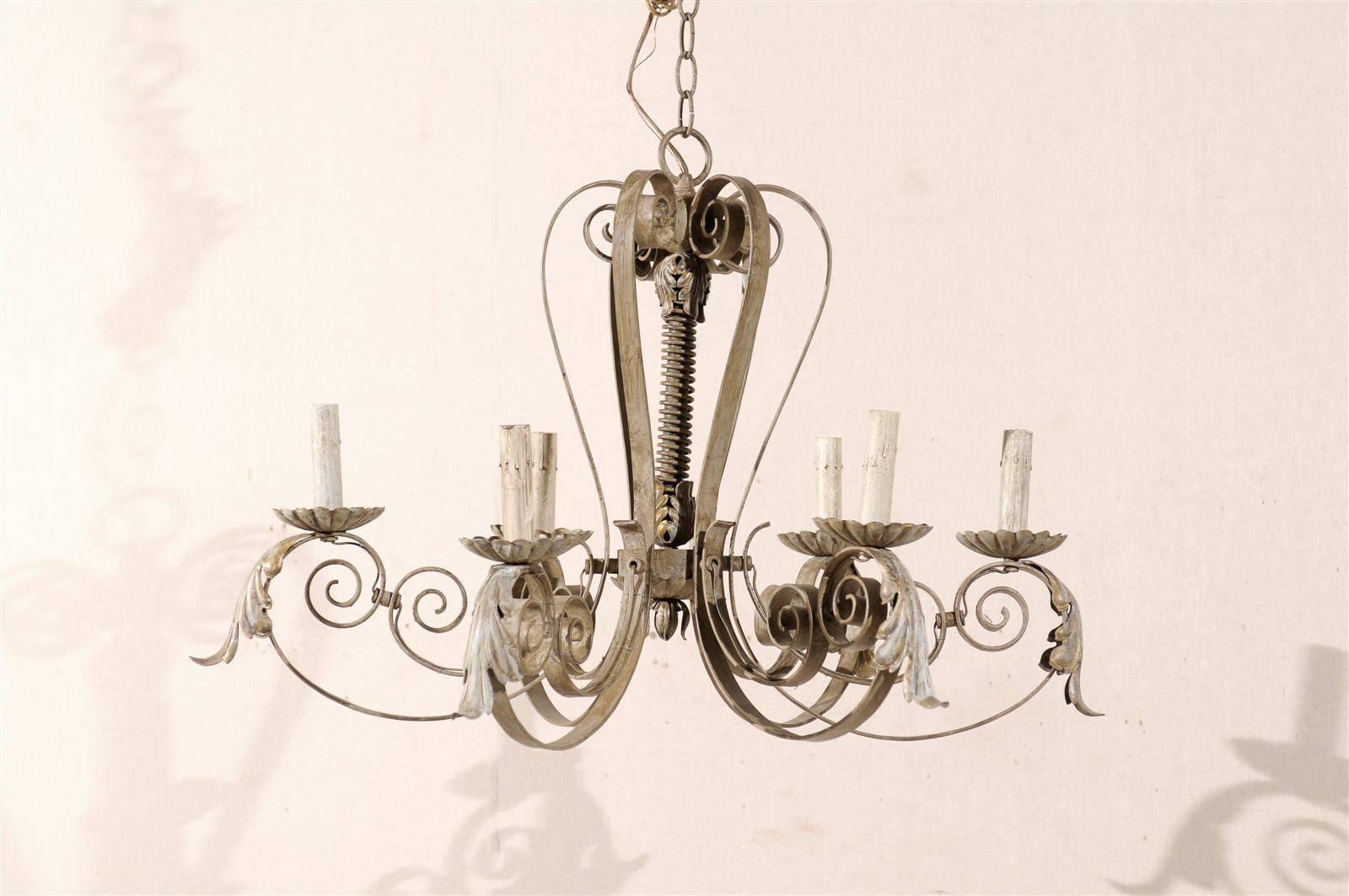 A French six-light painted metal chandelier with acanthus leaf motifs and scrolled arms. This chandelier has six scrolled arms. Above each arm is an additional decorative scroll motif. This chandelier is a soft warm grey color. Mid-20th century.
