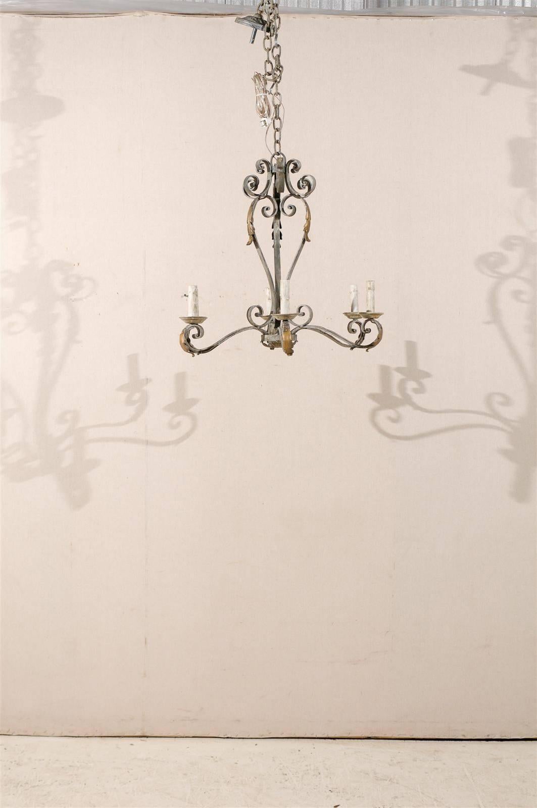 A French painted iron six-light chandelier with gilded acanthus leaves decor marking the end of the scrolled arms and wooden bobeches, from the Mid-20th century. The chandelier has been rewired for the US.