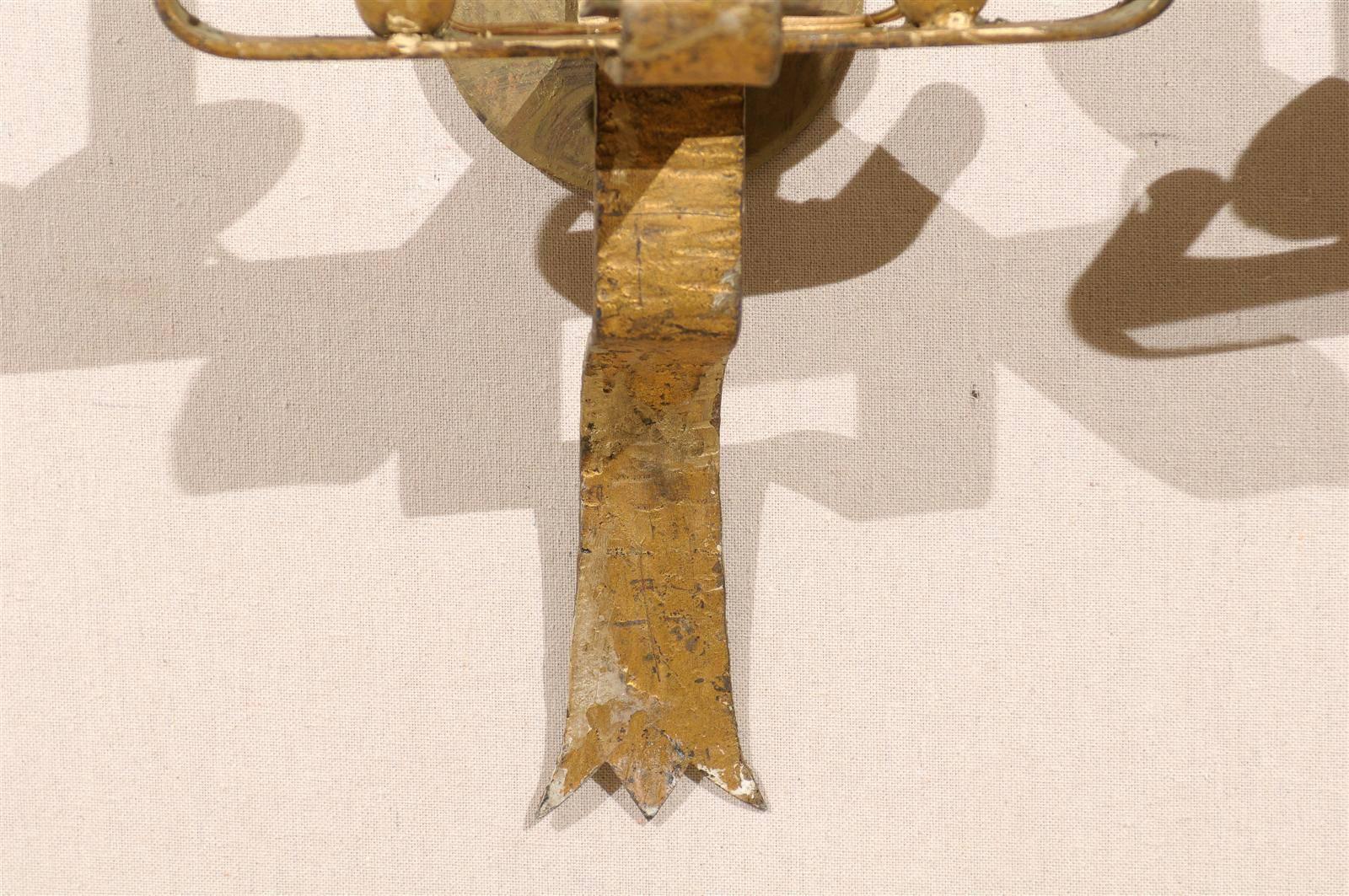 Paire d'appliques à deux lumières en métal doré, avec des volutes au sommet et des rinceaux soutenant les bobèches, 20e siècle. Ces appliques ont été recâblées pour les États-Unis.