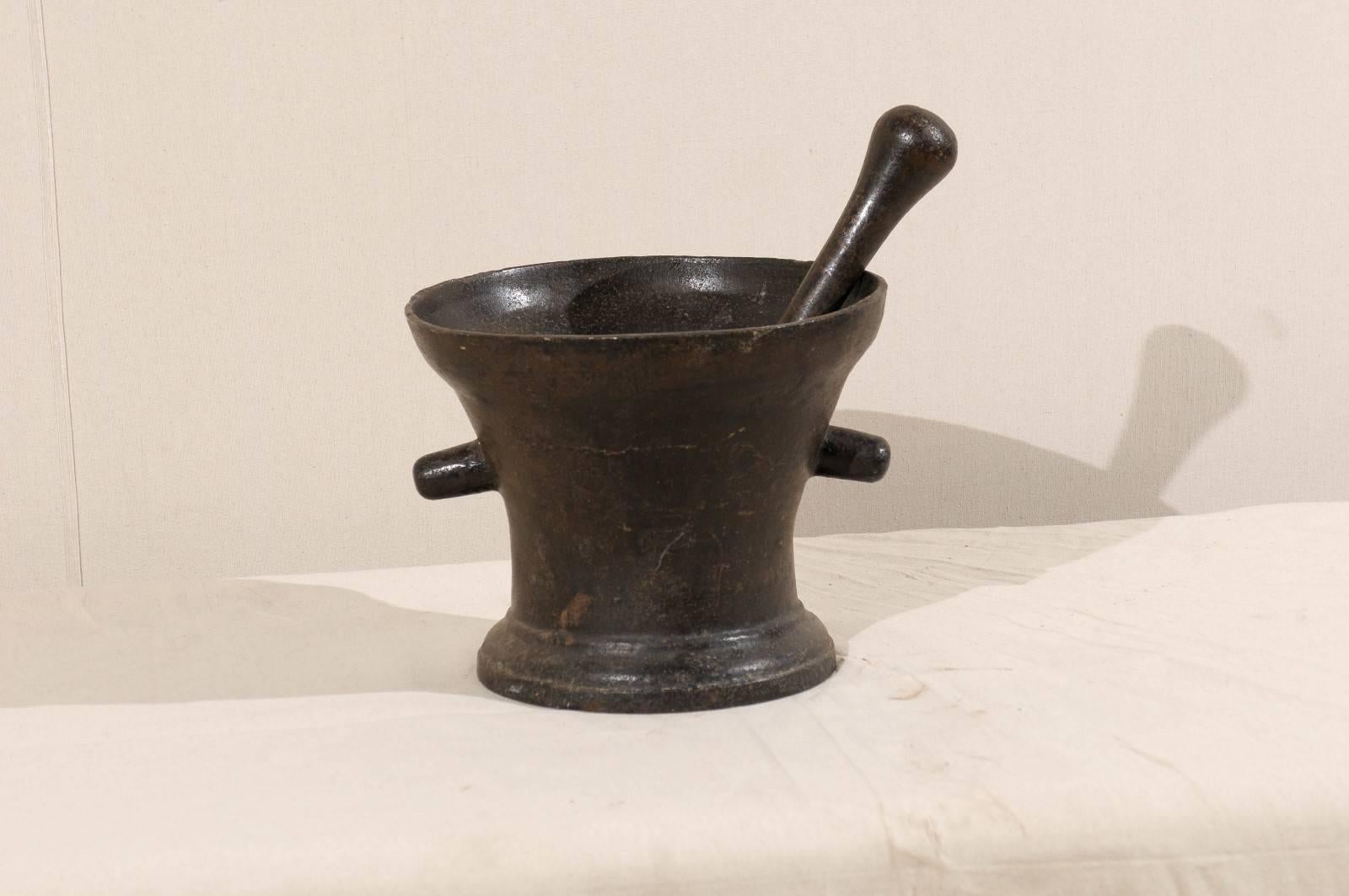 An Italian, 18th century mortar and pestle. This iron mortar and pestle has a nice heavy weight and patina and features two handles.