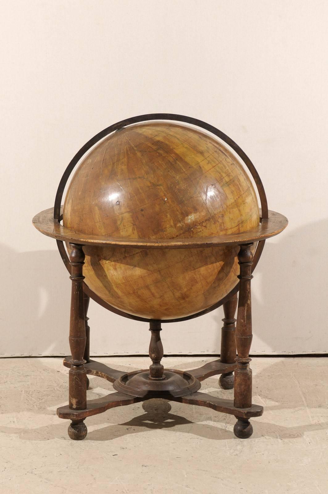 An Italian 19th century large globe on wooden stand. This velum covered globe is heavily foxed and has nice age to it which makes only the countries on the lower half of the globe visible. This Italian globe is raised on four turned legs connected