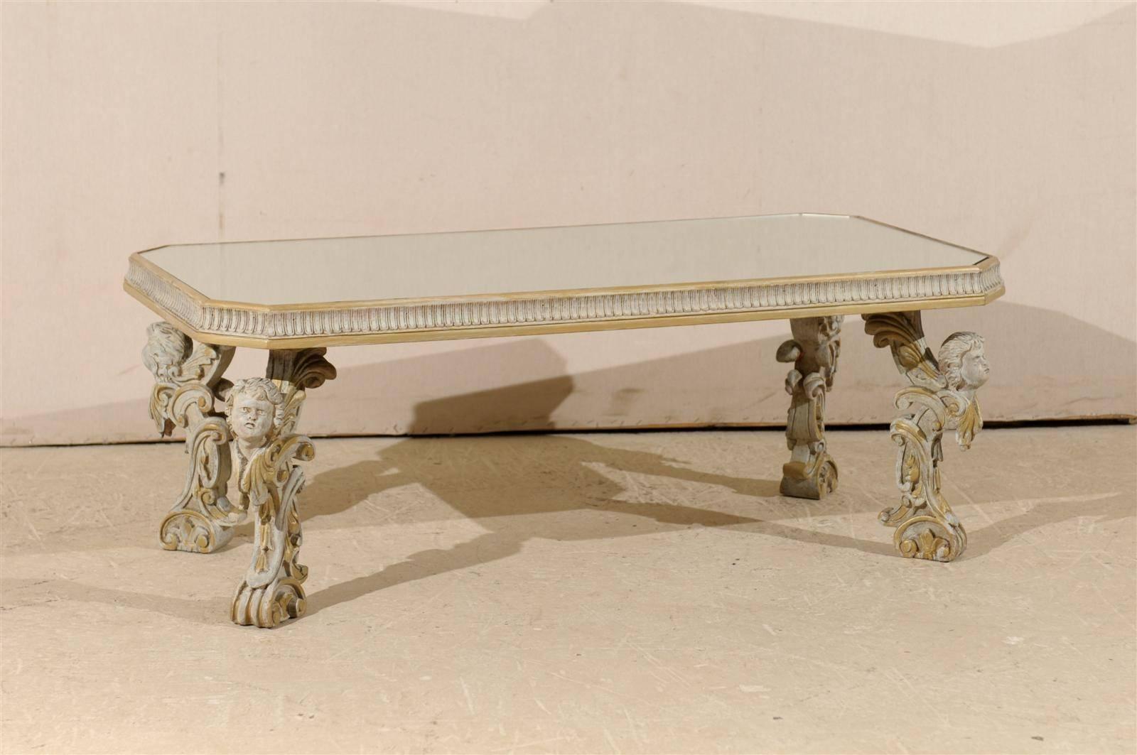 An Italian mirrored top wooden coffee table with putti-carved legs from the early 20th century. This exquisite Italian coffee table from the 1920s is made of a mirrored top with chamfered sides, over richly embellished legs, each decorated with a