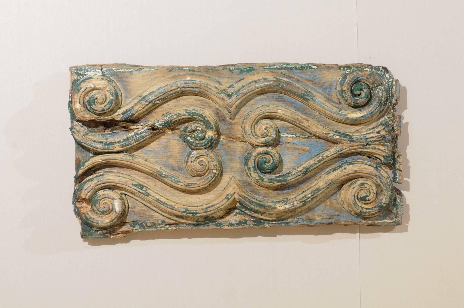 An Italian painted wood carved decorative wall hanging plaque. This late 18th-early 19th century wooden Italian horizontal shaped wall decoration features a nice decor of volutes, forming two stylized horizontal heart-shaped motifs in its center.