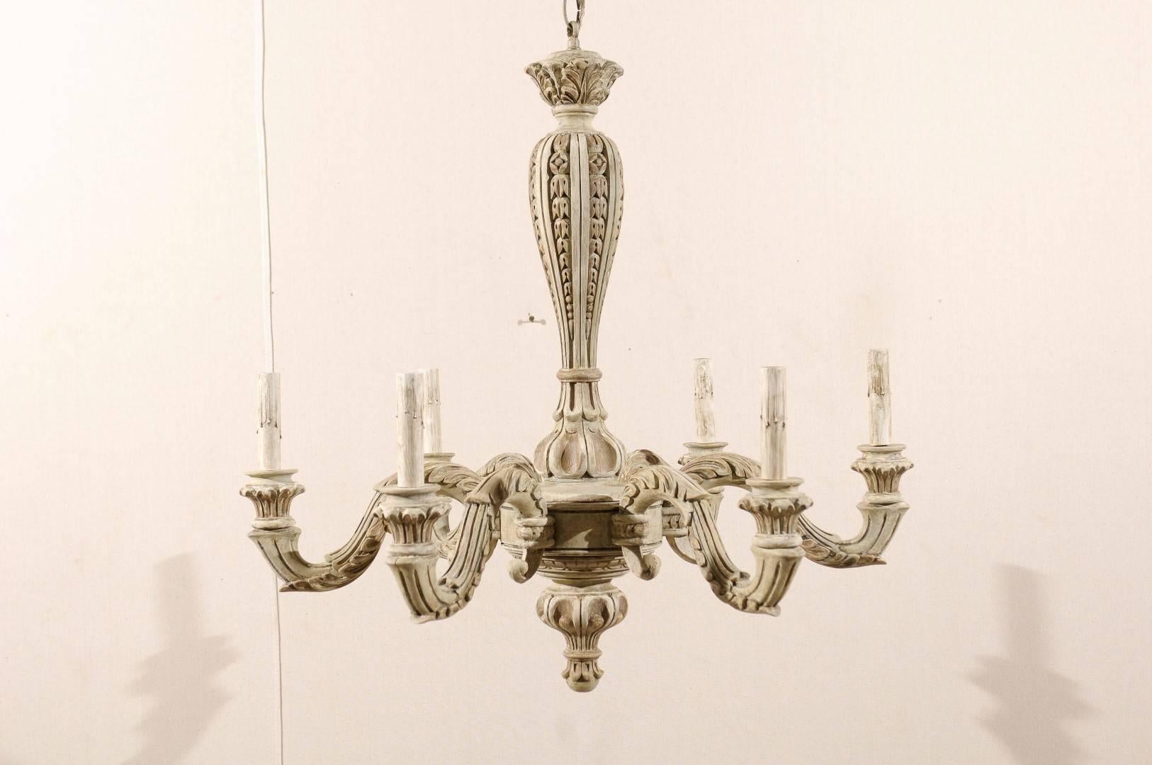 A French six-light painted and carved wood chandelier with scroll arms and wood bobèches. This French mid-20th century chandelier features a central carved column. The S-scroll arms are supporting wooden bobèches and painted candle sleeves. The