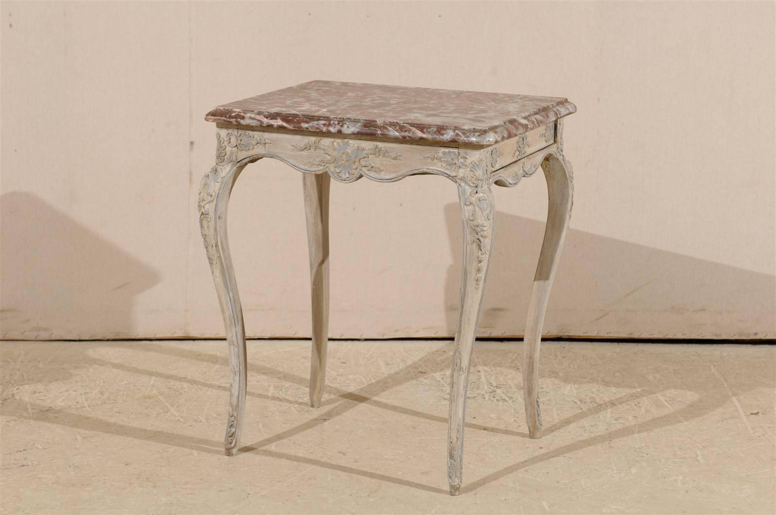 A French early 19th century side table. This elegant French Louis XV Style side table features a red marble top. The scalloped skirt and slender cabriole legs are decorated with floral ornaments. The table has a single drawer located on one of the