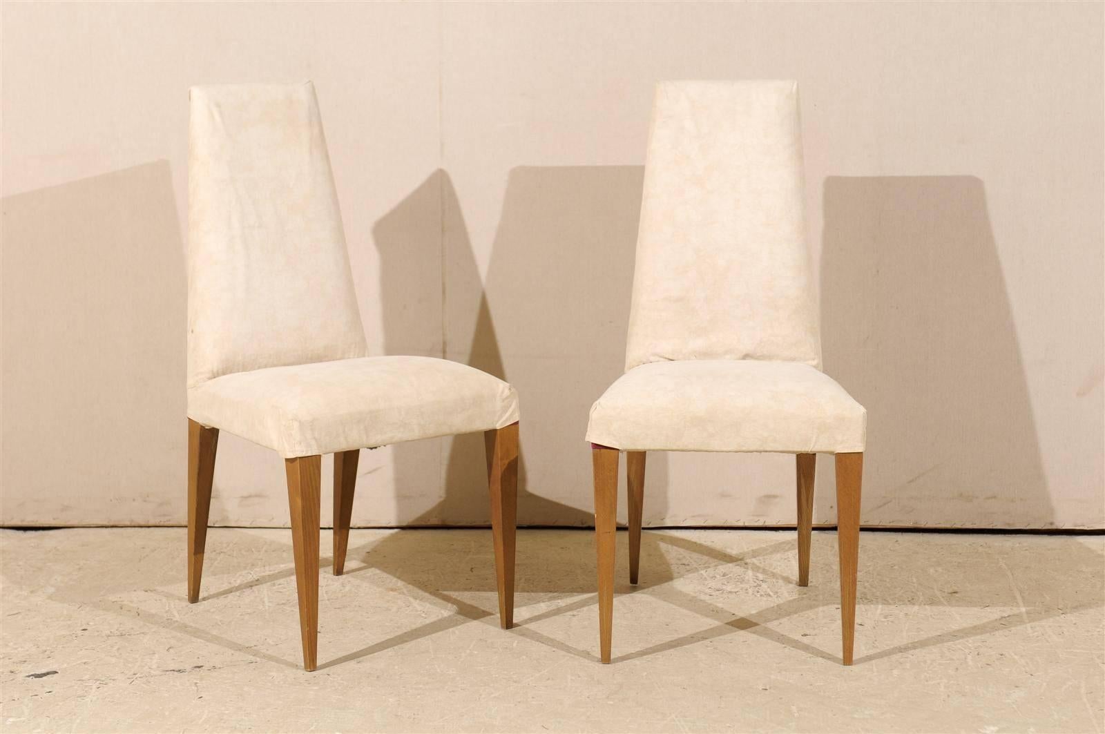 A set of six French modern slip covered side chairs with tapered legs from the mid-20th century. These chairs feature clean lines and have usable slip covers (ready to be cleaned, there is a little bit of wear).